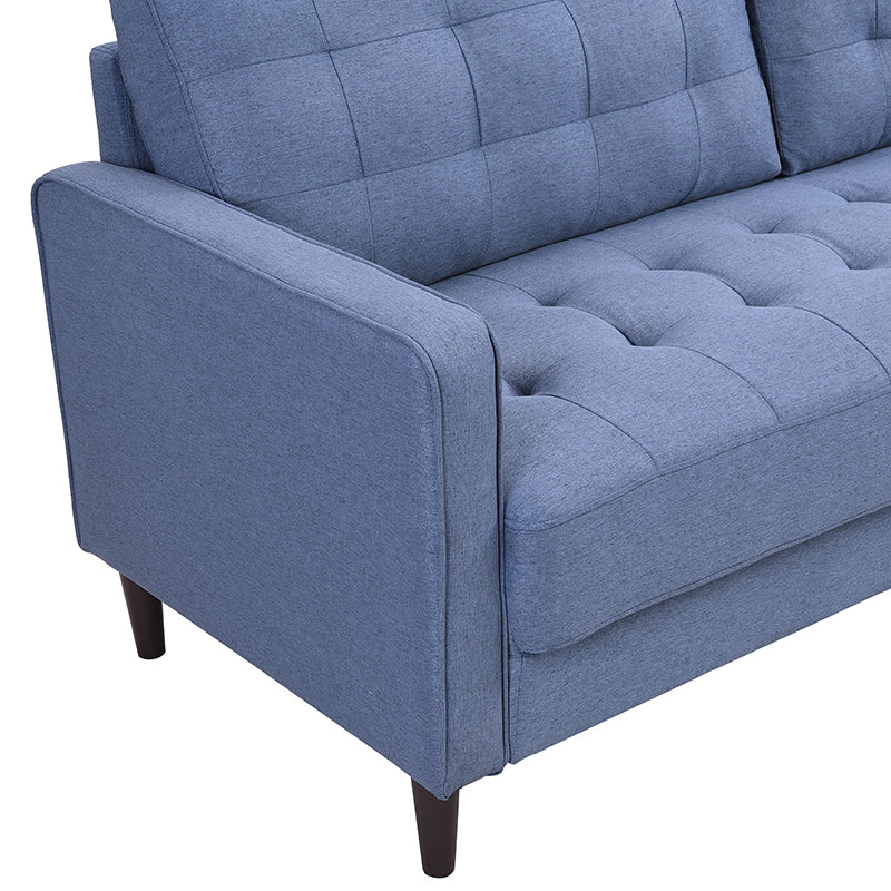 Closeup of a blue tufted couch armrest with tailored stitching and dark wooden legs