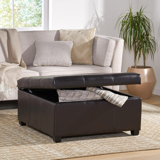 Dark brown faux leather storage ottoman with open lid and rolled blankets inside