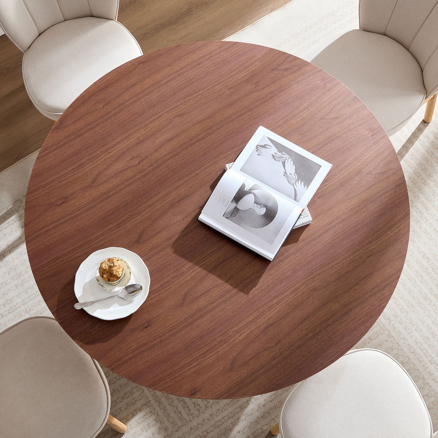 Round walnut dining table with open book and pastry perfect for modern kitchens