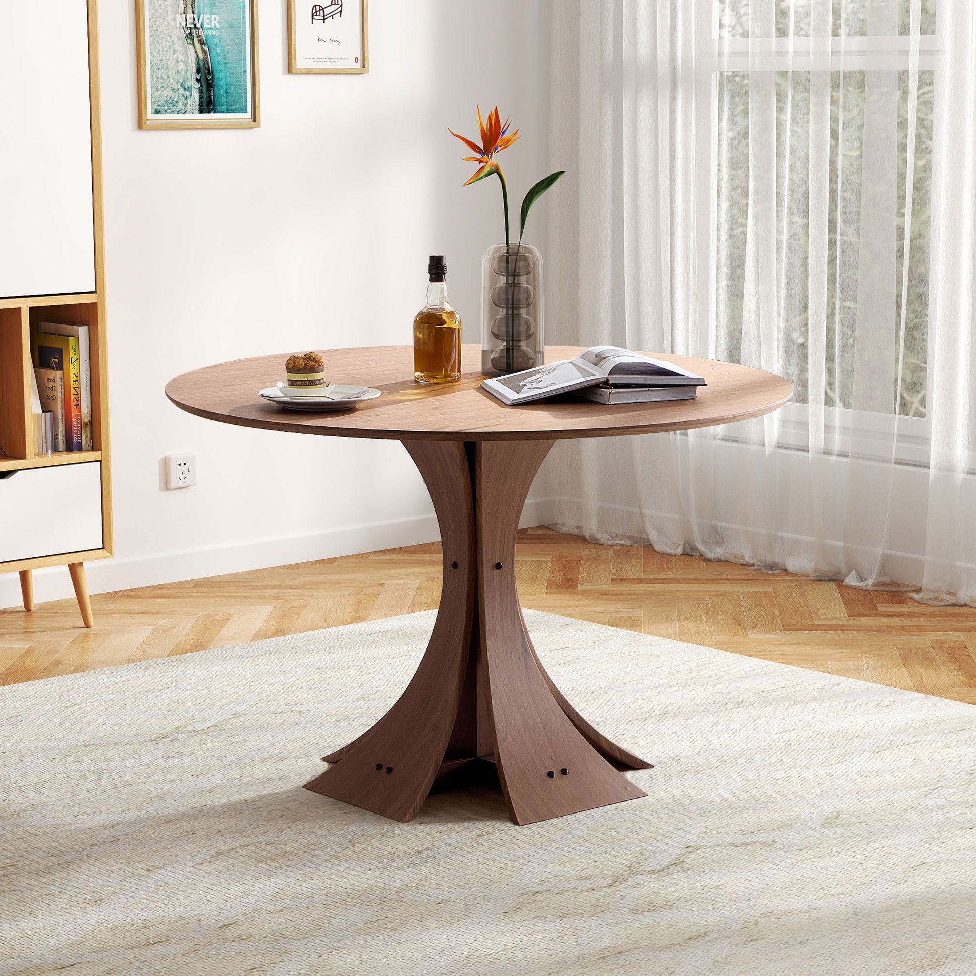 Round wood dining table with a sculptural pedestal base perfect for small spaces