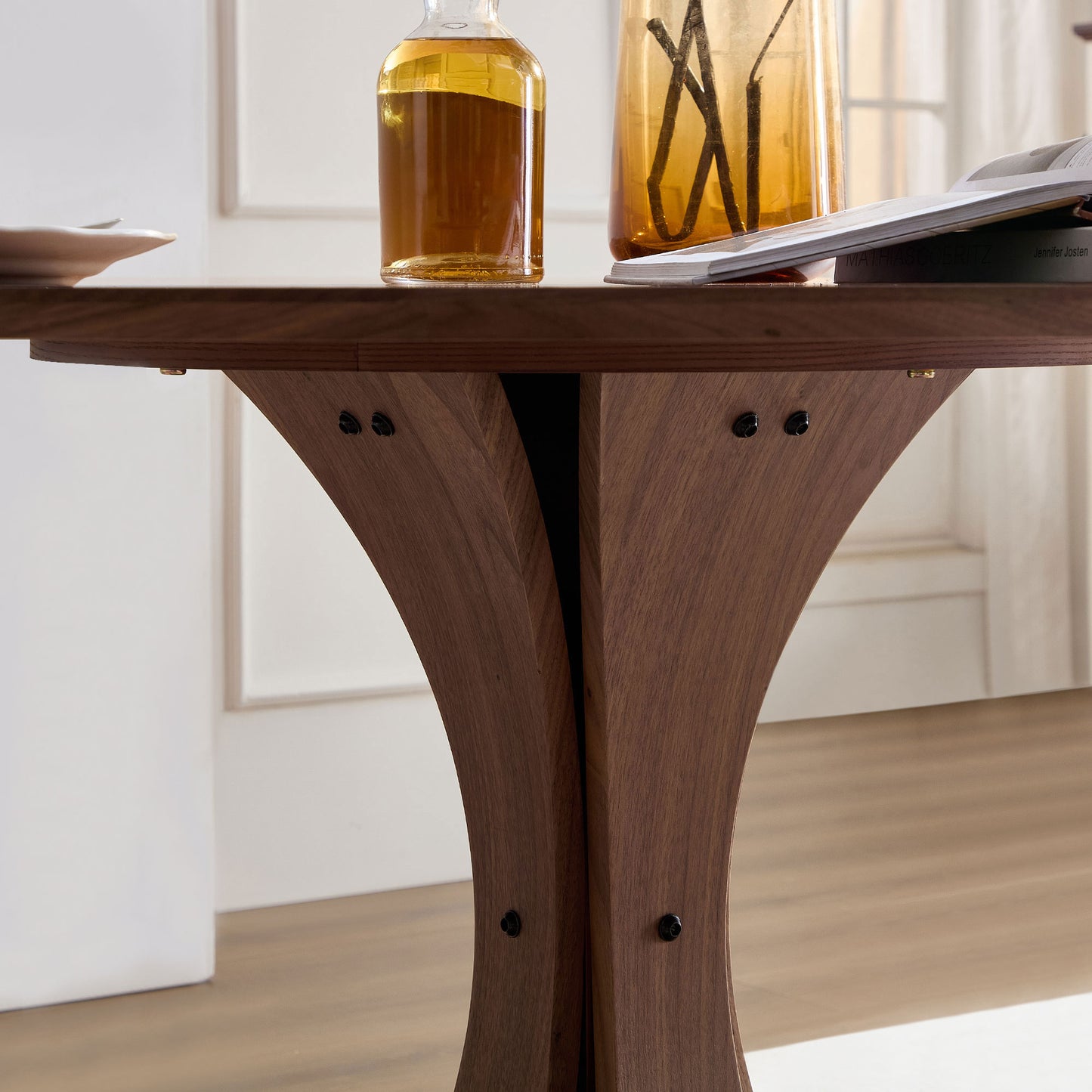 Solid walnut dining table base with a modern sculptural design and dark metal accents