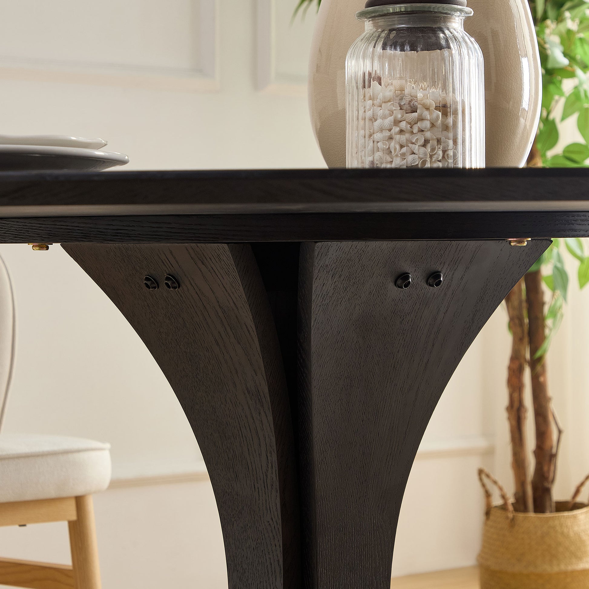 Dark oak pedestal dining table base with curved legs showcasing wood grain detail