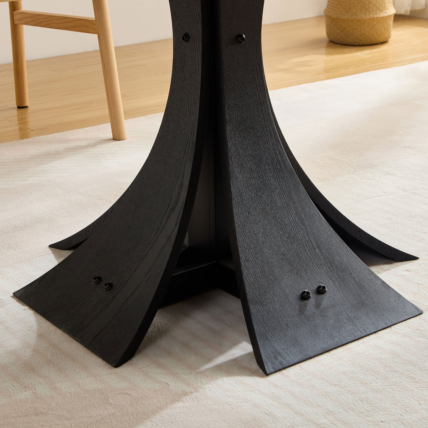 Closeup of a black wood pedestal base with a textured grain pattern