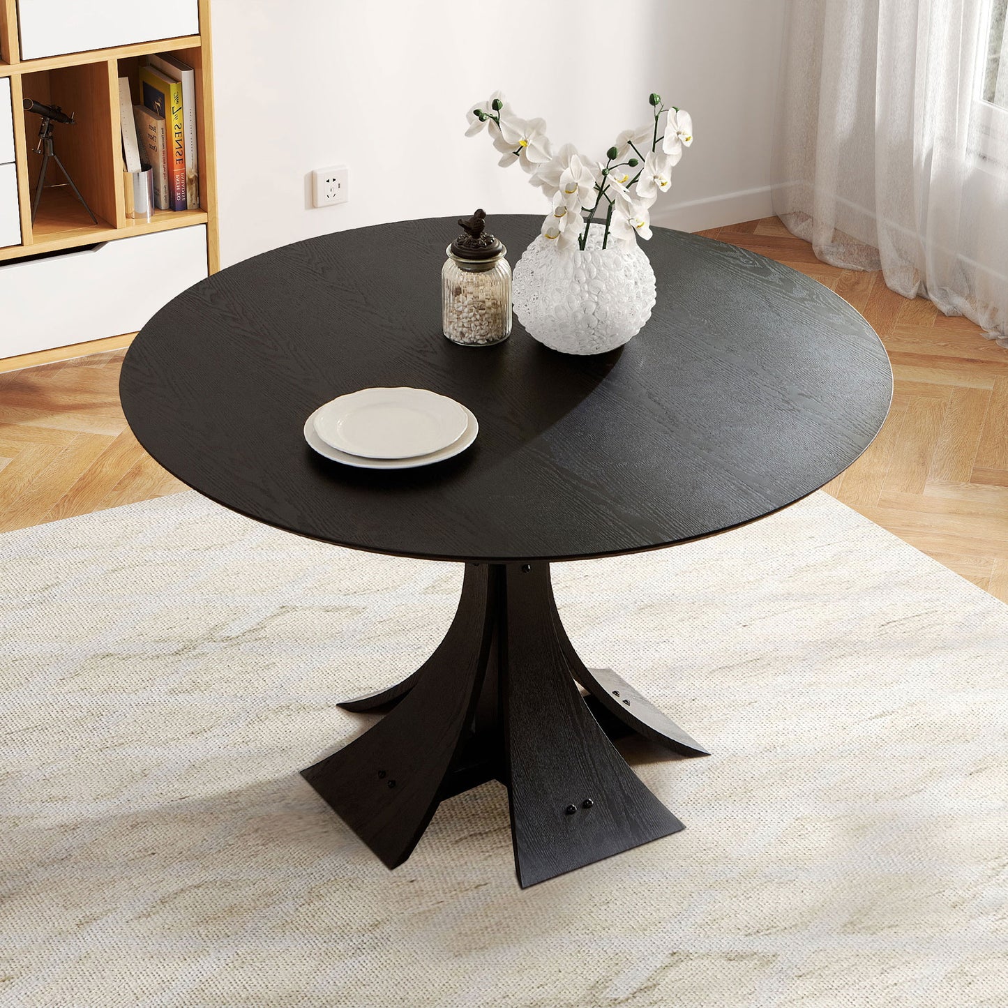 Dark wood round dining table with a unique pedestal base and two white plates