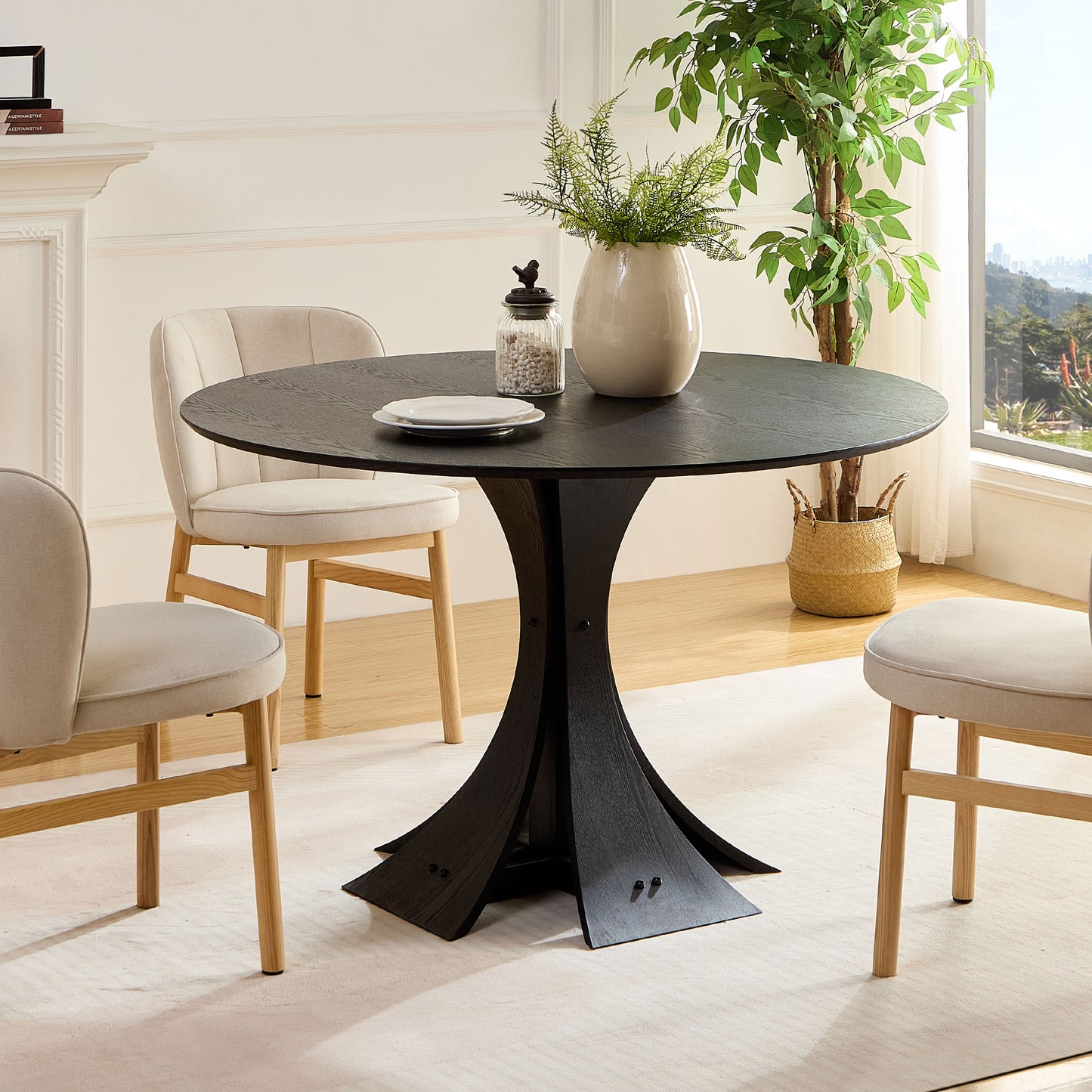Round black wood dining table with flared base seats four