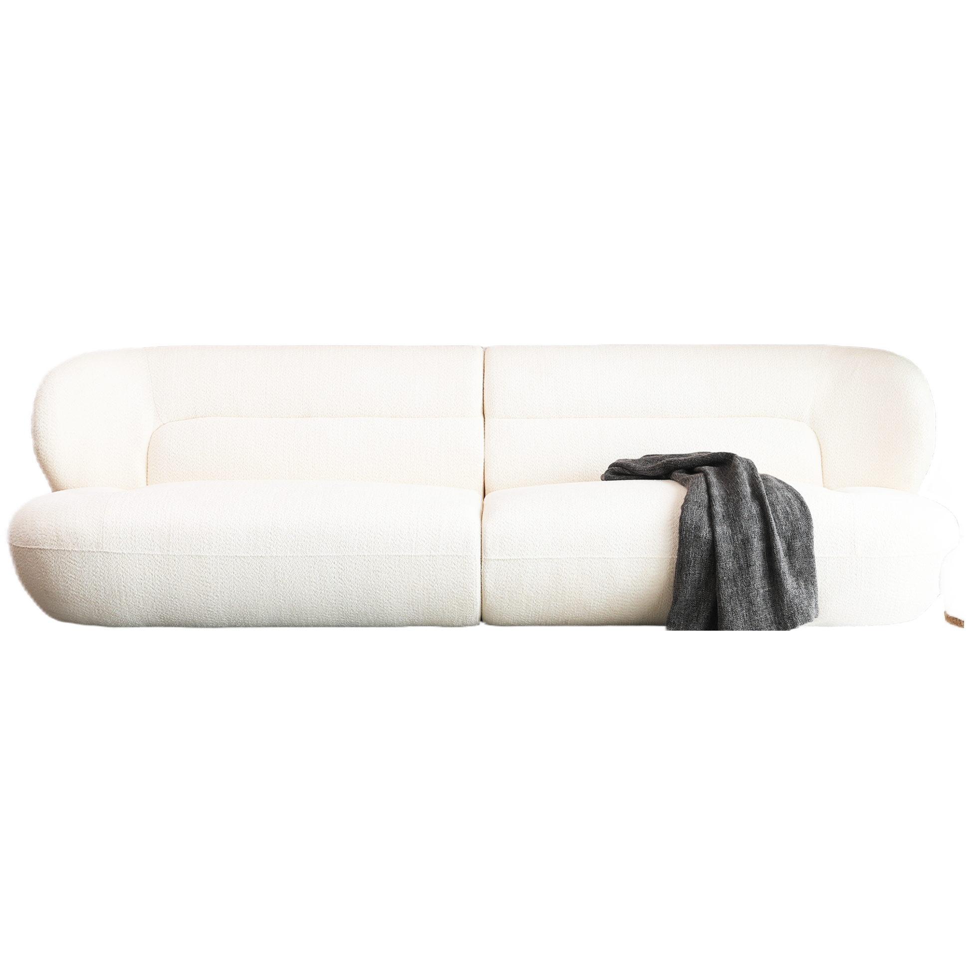 Plush boucle white fabric sofa with rounded arms and a folded charcoal throw