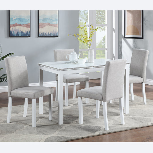 White rectangular dining table with four upholstered grey chairs and decorative trim