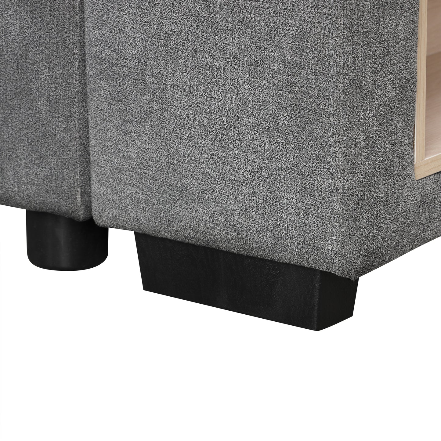 Closeup of a gray textured sofa armrest with a wooden accent shelf visible