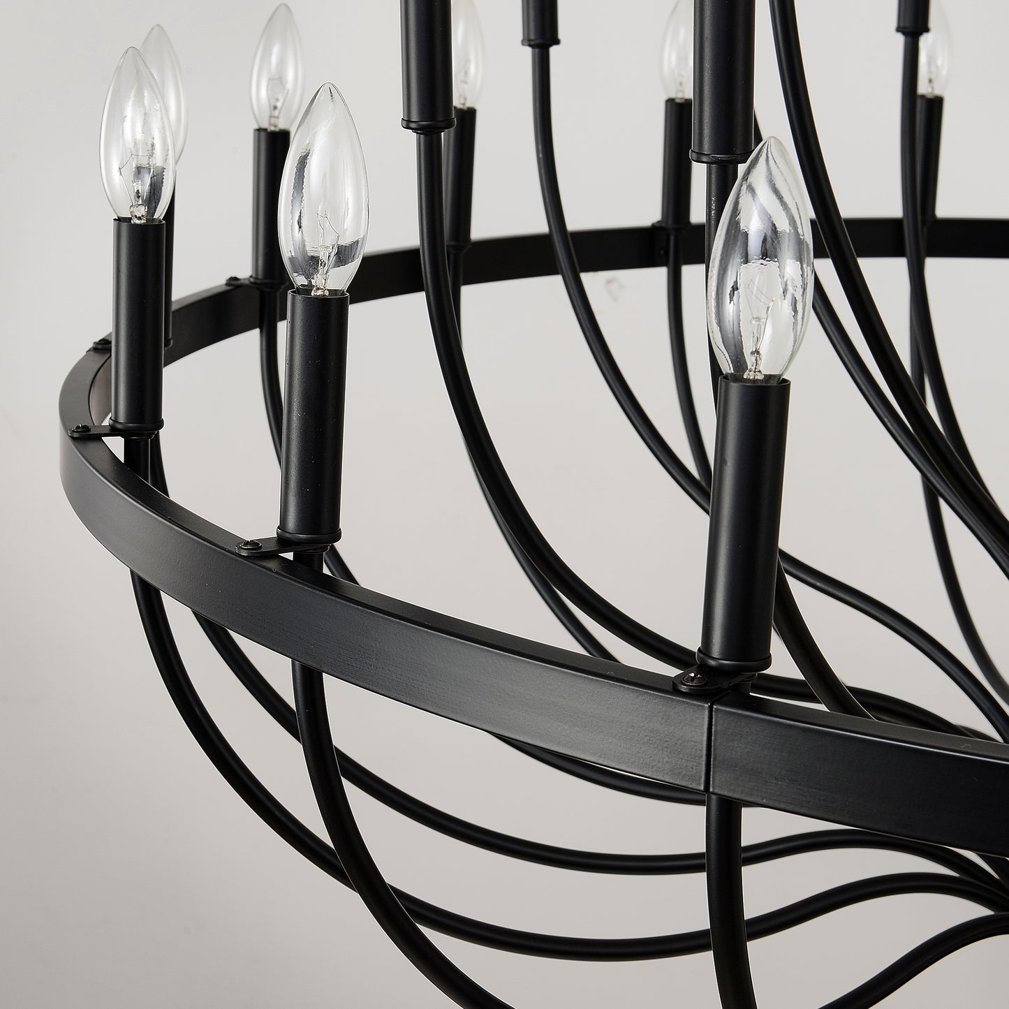Closeup of a black metal chandelier featuring clear Edison bulbs modern style