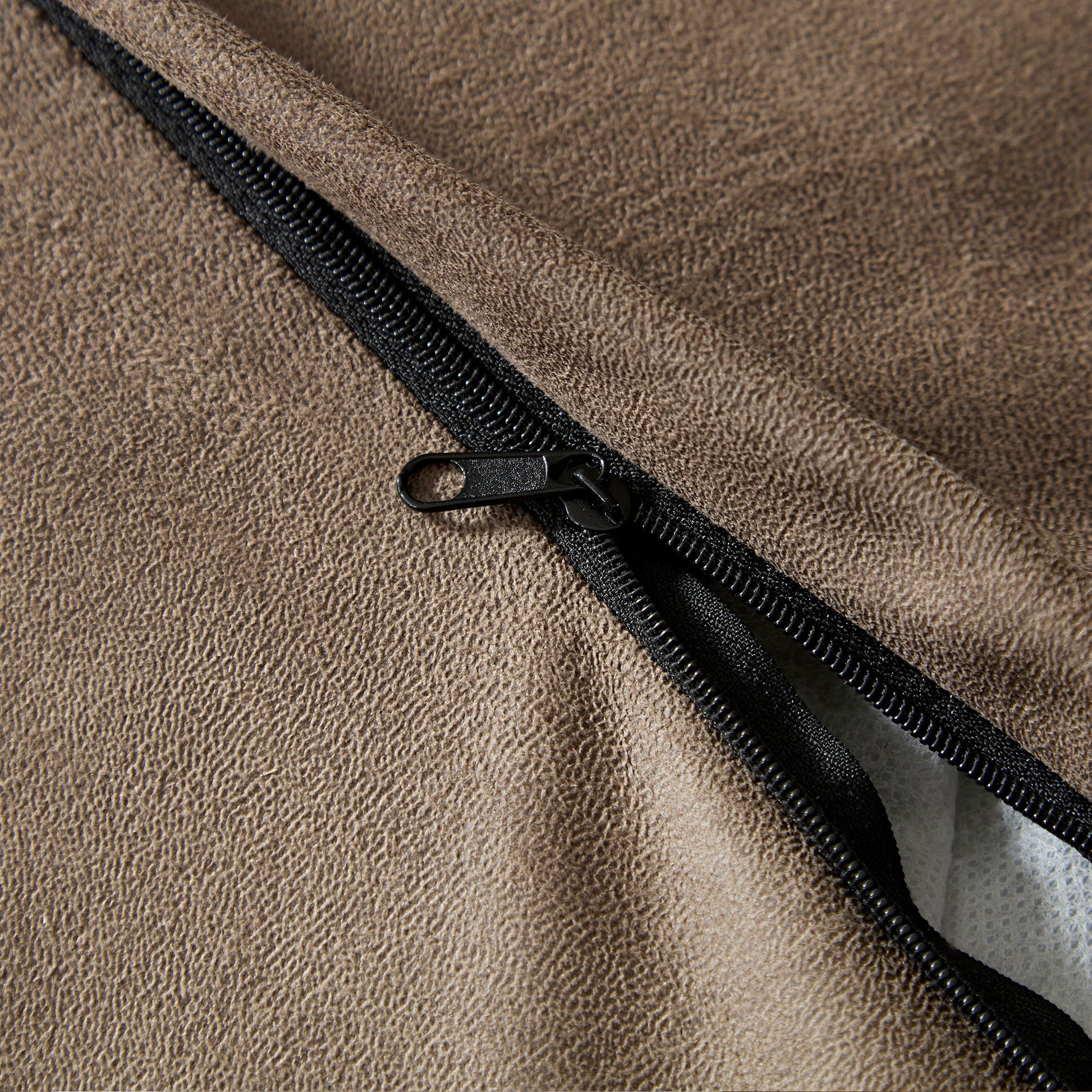 Brown faux leather texture with black zipper detail on a cushion cover