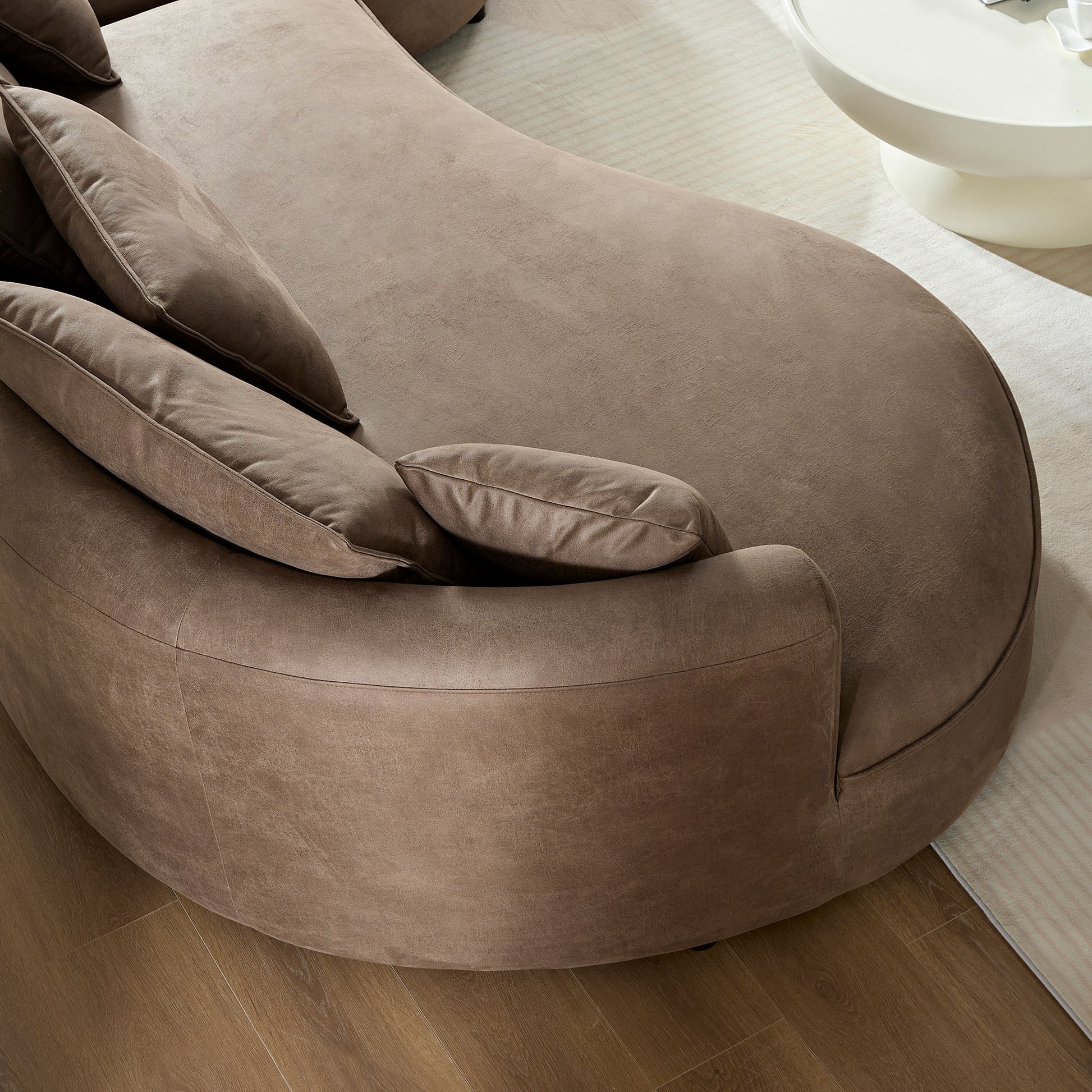 Curved taupe suede sectional sofa with plush cushions perfect for modern living rooms
