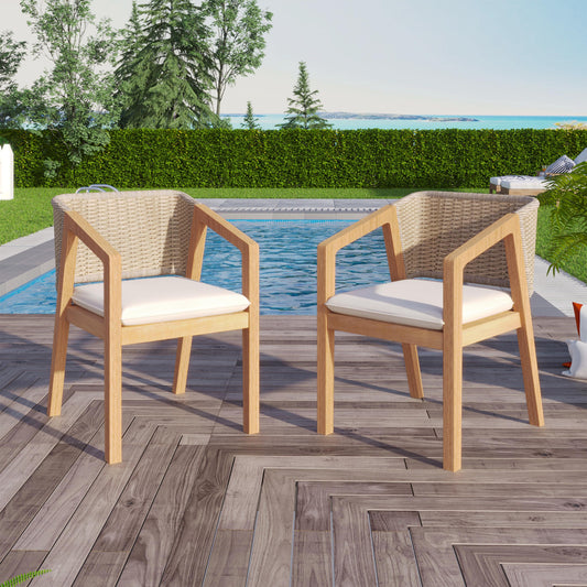 Two wicker outdoor chairs with white cushions on a wooden deck by a pool