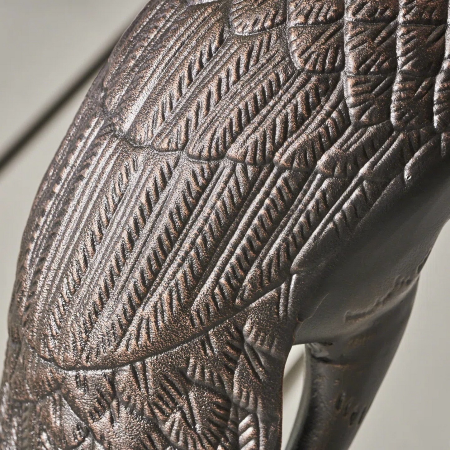 Textured bronze garden statue of a bird with detailed feathering