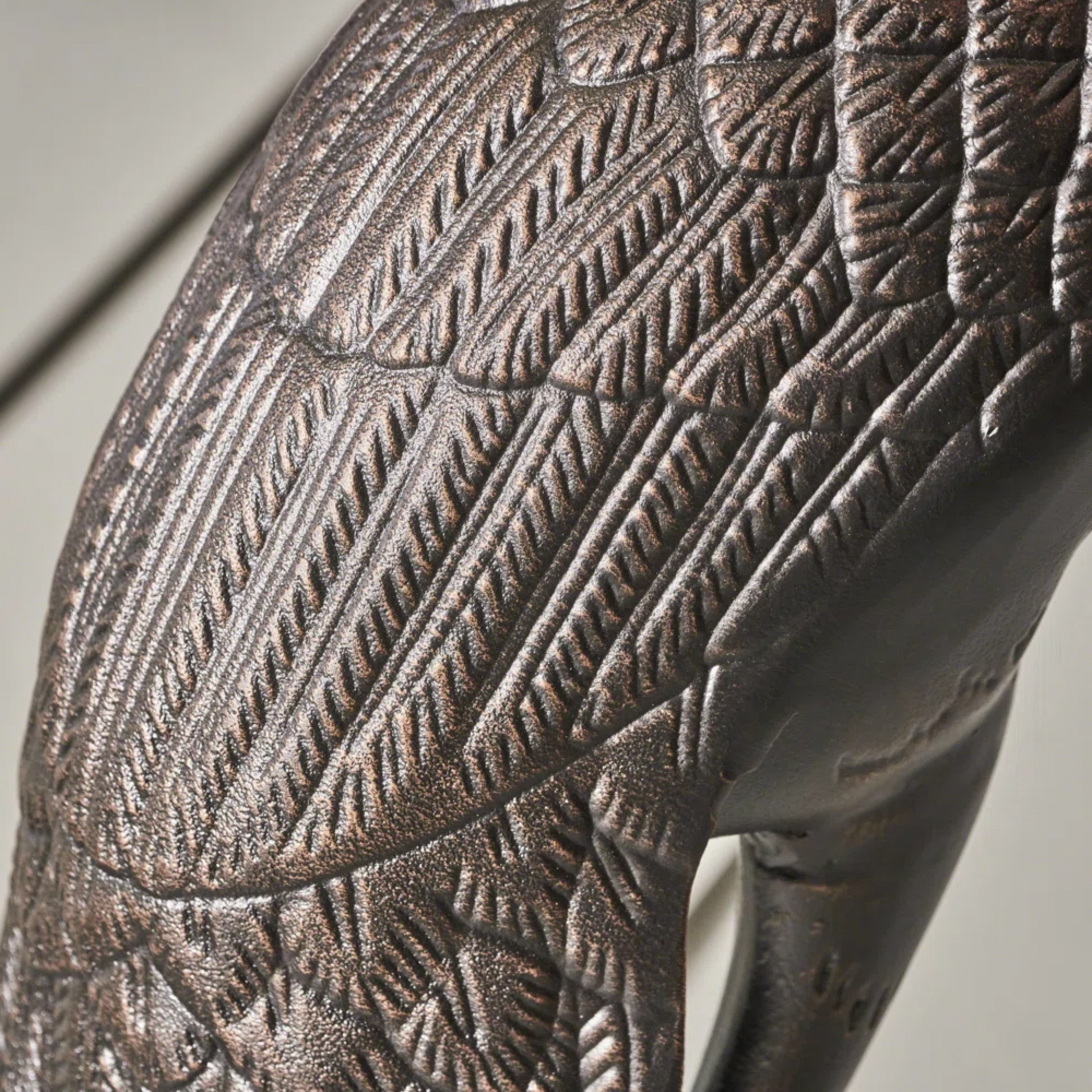 Textured bronze garden statue of a bird with detailed feathering
