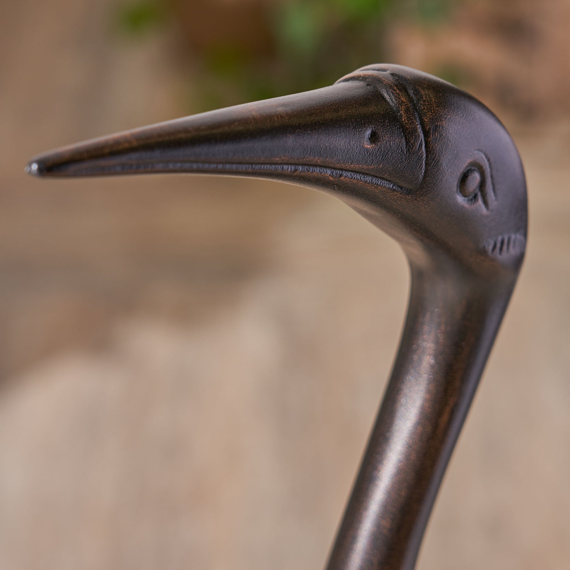 Dark bronze heron garden statue head detail with textured finish