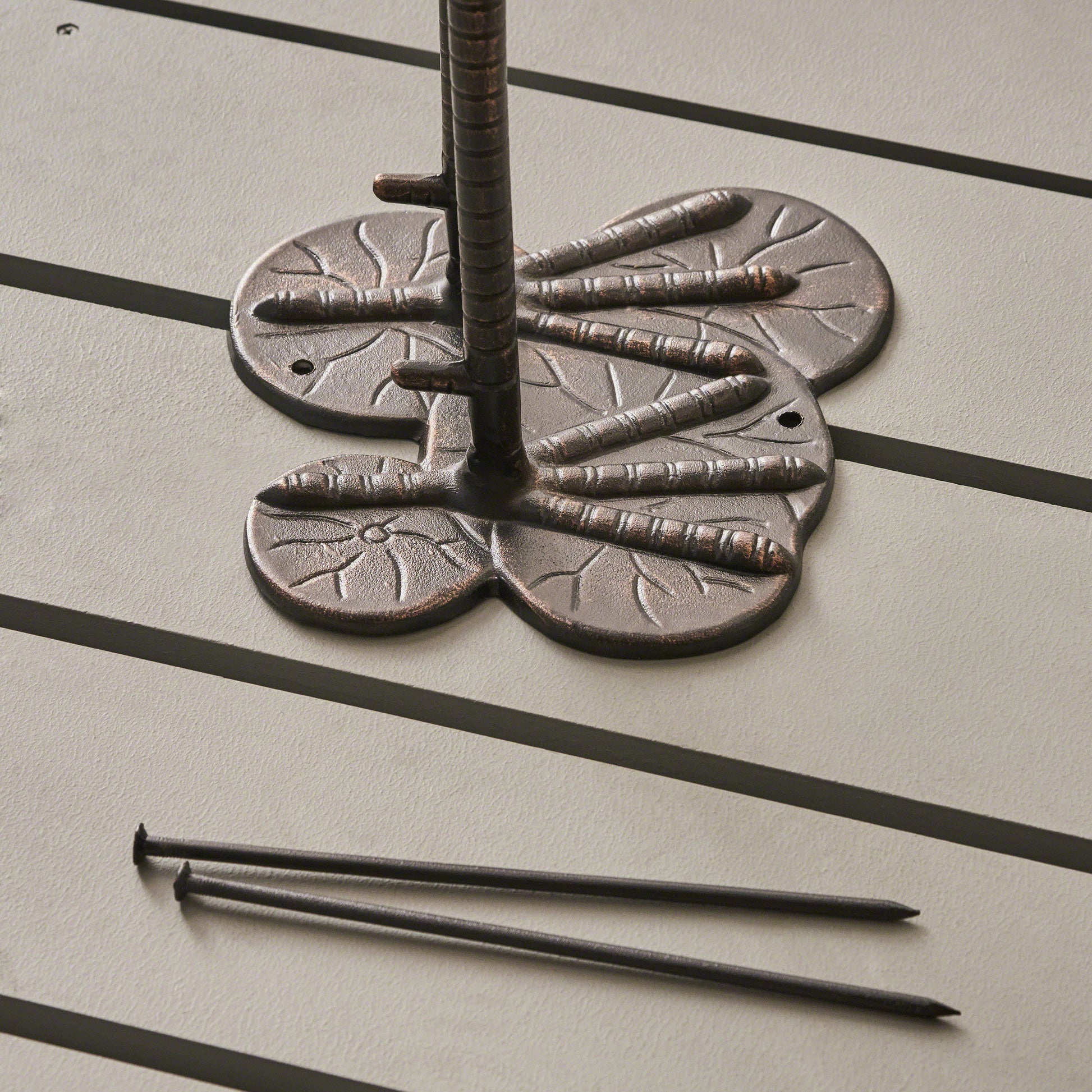 Bronze garden stake base with dragonfly detail and metal garden stakes
