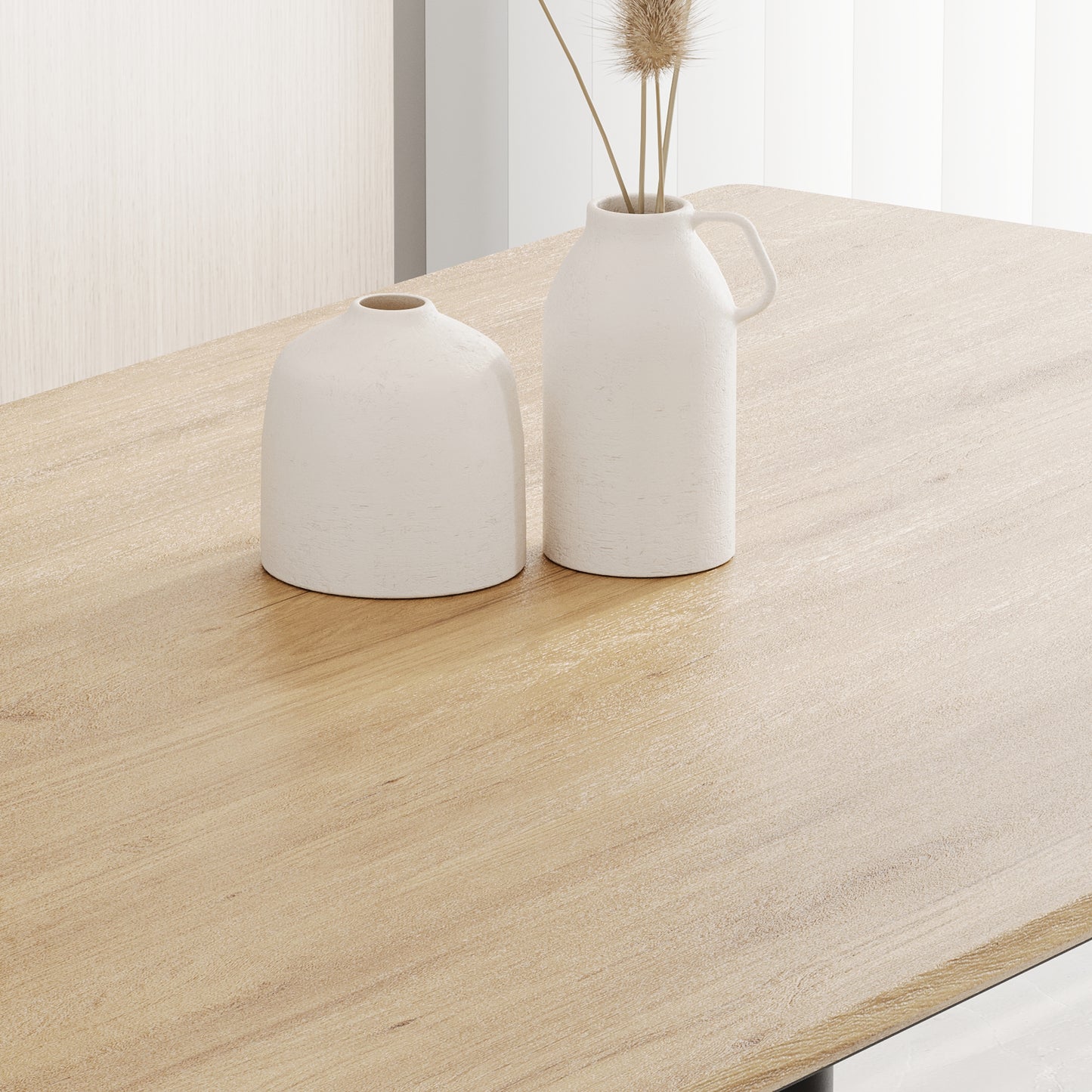 Modern light oak dining table with textured white ceramic vases and dried grass centerpiece