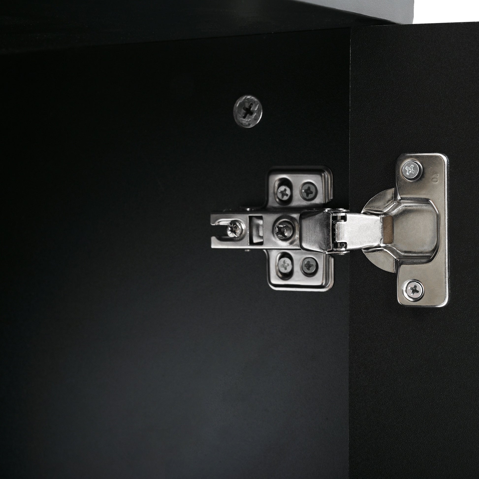 Closeup of a polished chrome cabinet hinge with visible screws on a black surface