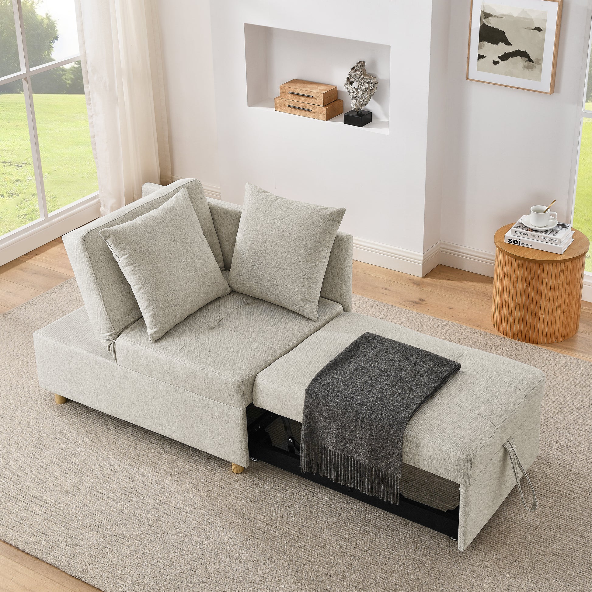 Light beige linen sofa bed with plush cushions and a grey throw blanket on ottoman