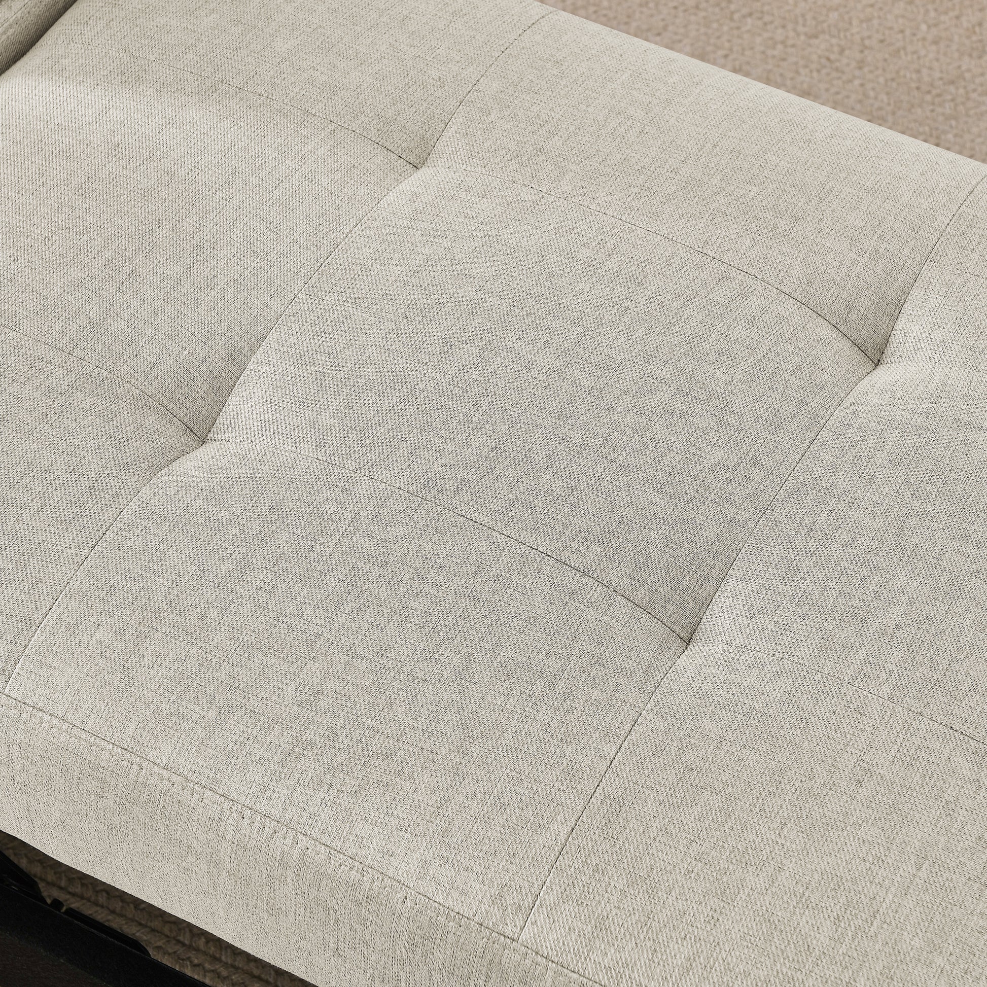 Closeup of beige linen tufted storage ottoman with button accents