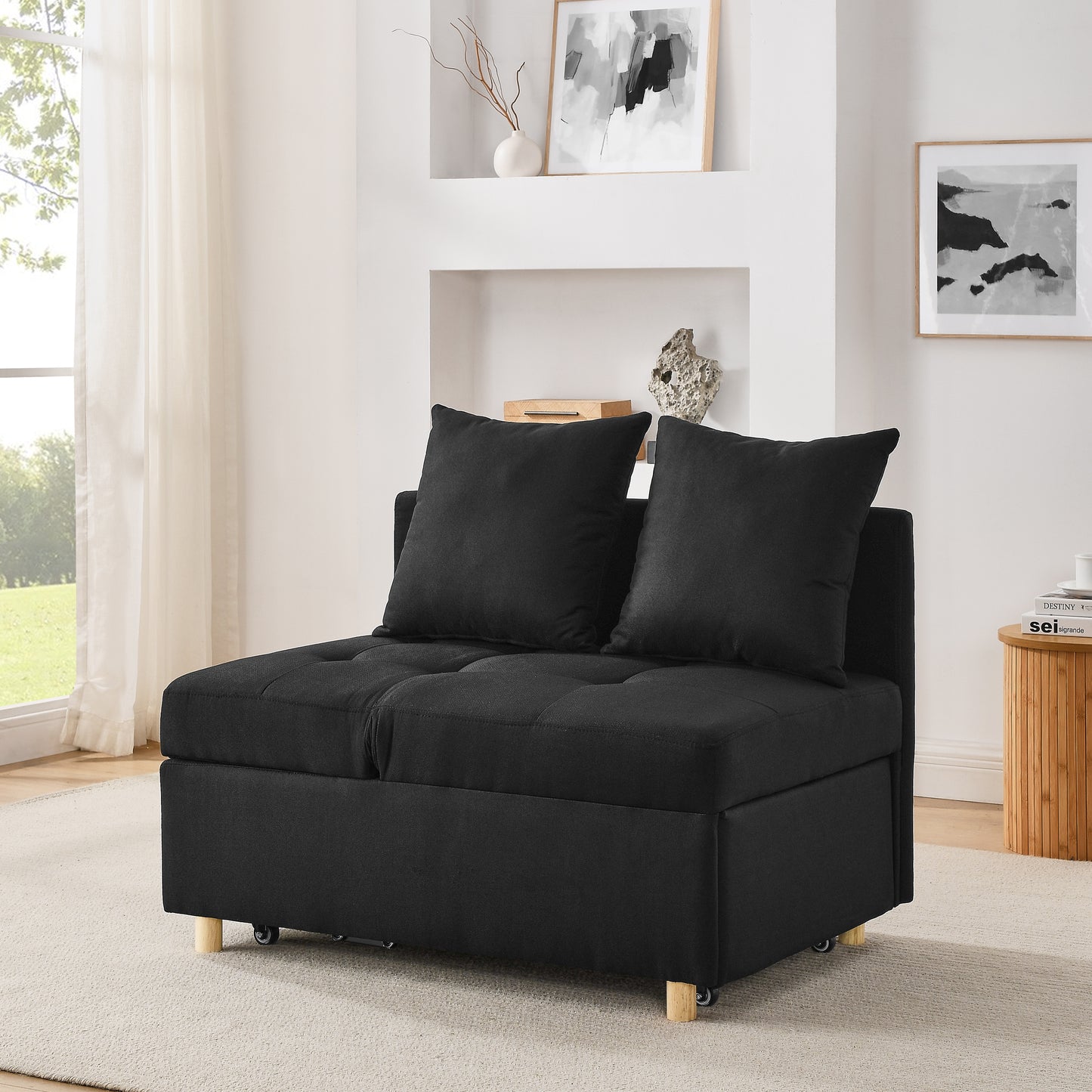 Tufted black fabric sofa bed with two throw pillows ideal for small spaces