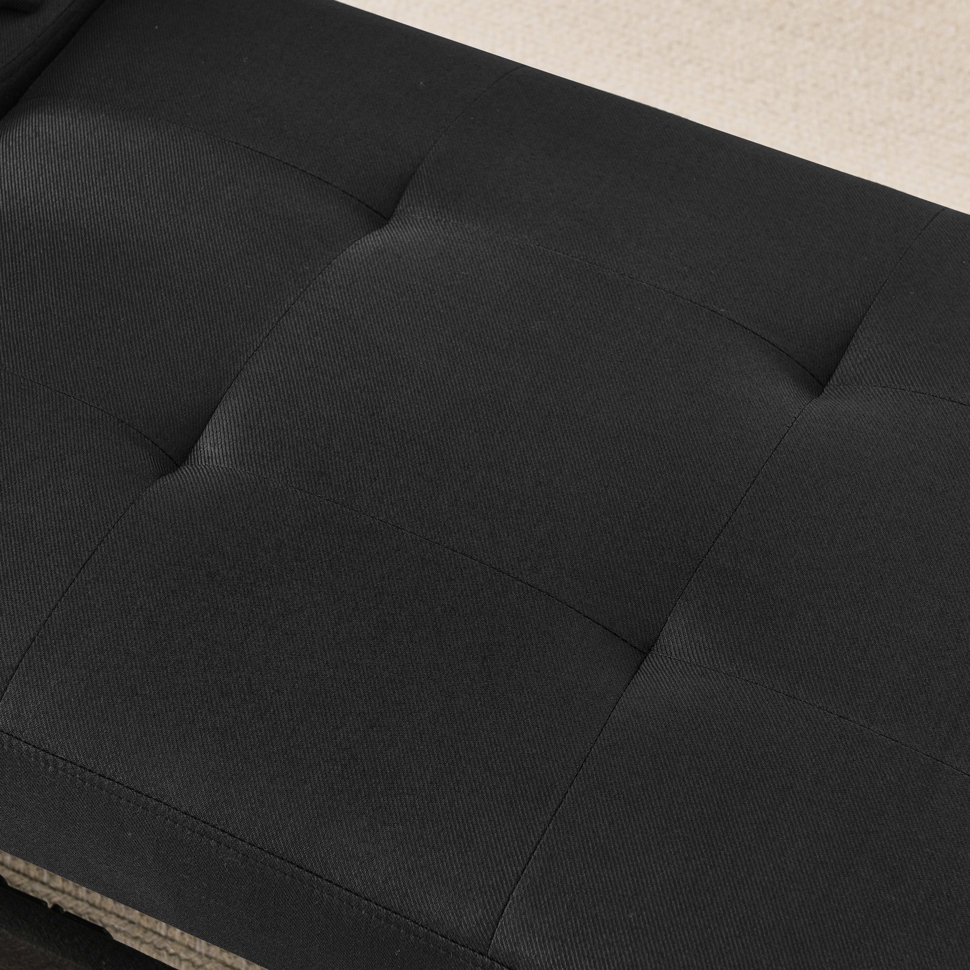 Closeup of tufted black fabric couch cushion modern design