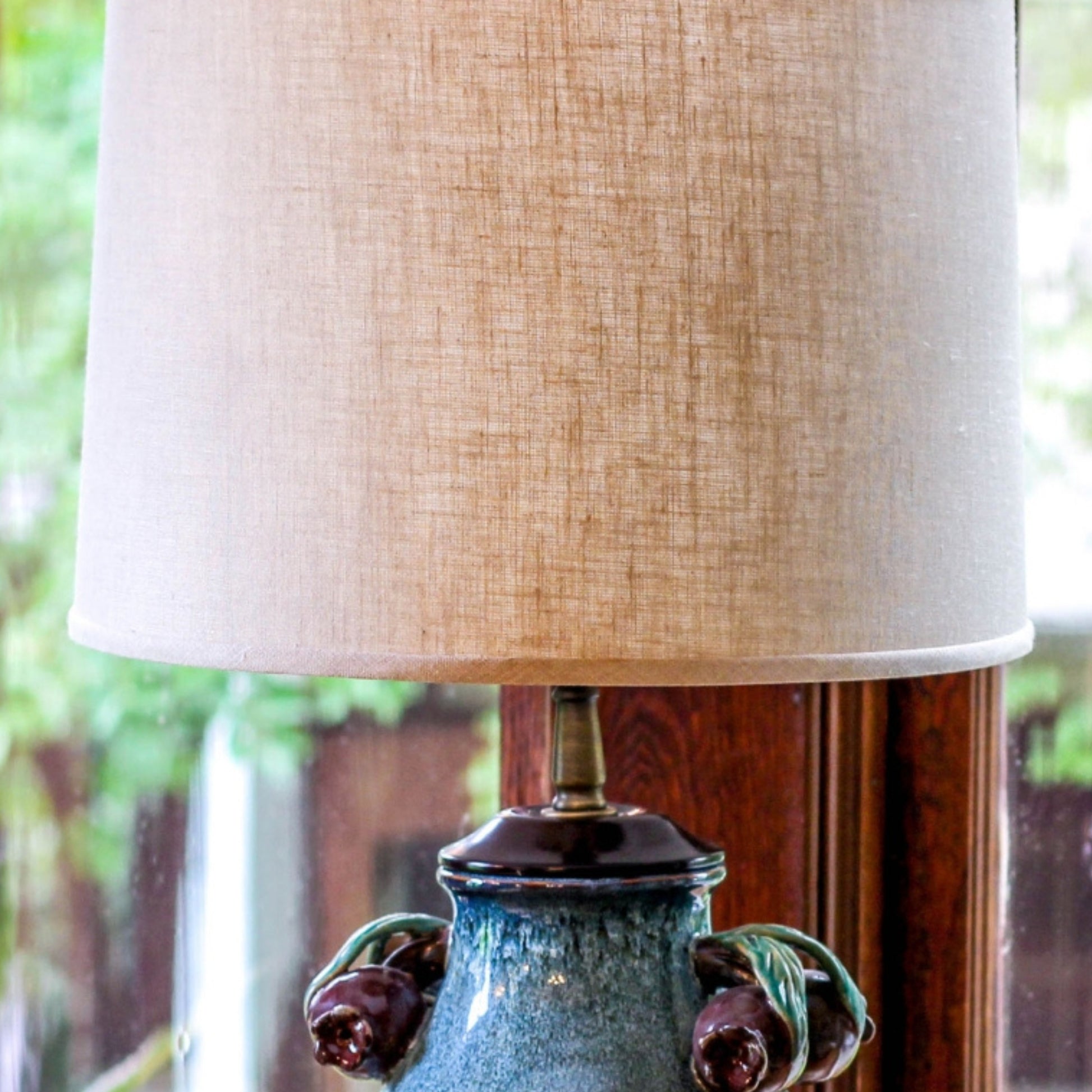 Textured linen lampshade with a rustic base featuring decorative floral accents