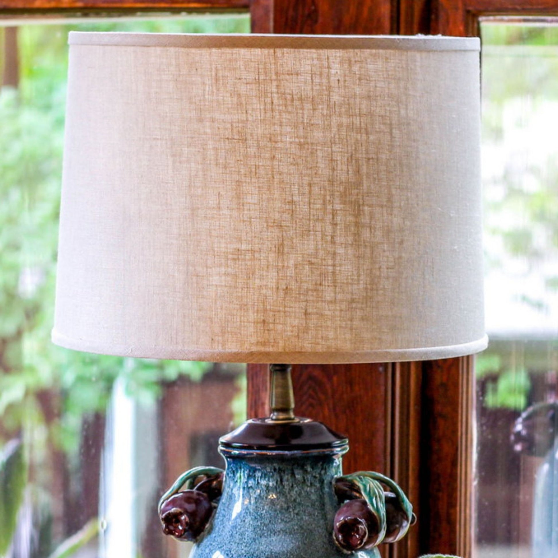 Textured beige linen drum lampshade with ornate blue ceramic base