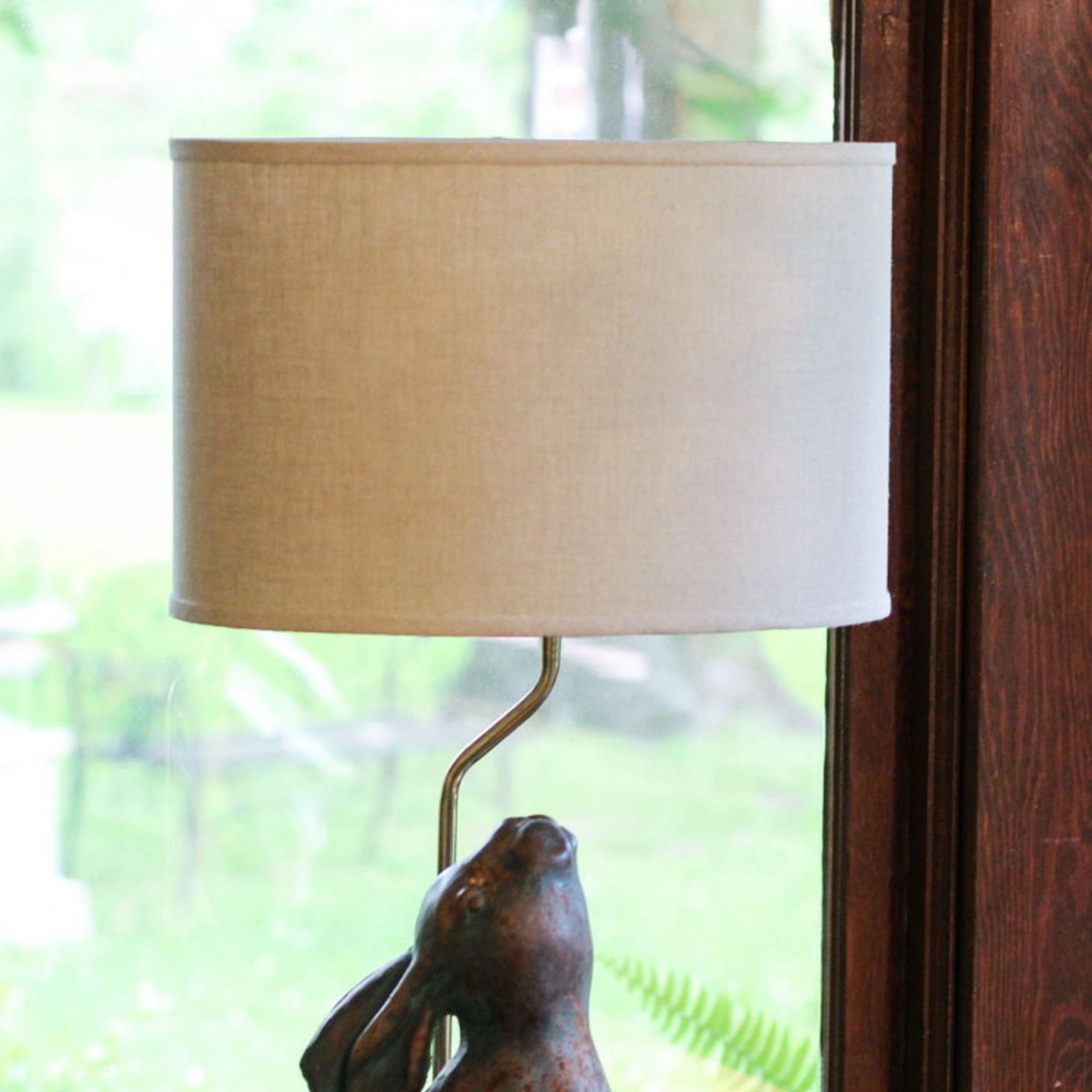 Bronze rabbit lamp base with beige linen drum shade ideal for accent lighting
