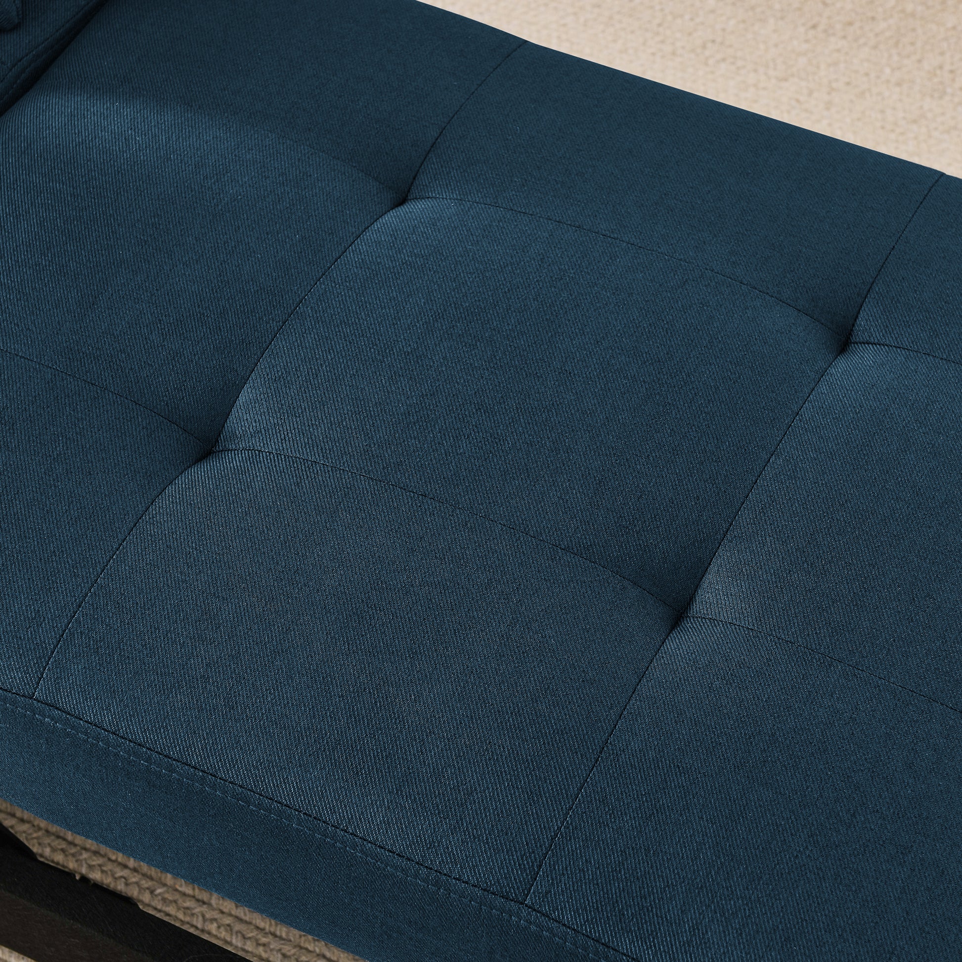 Deep blue fabric ottoman with tufted cushion detail perfect for entryway seating