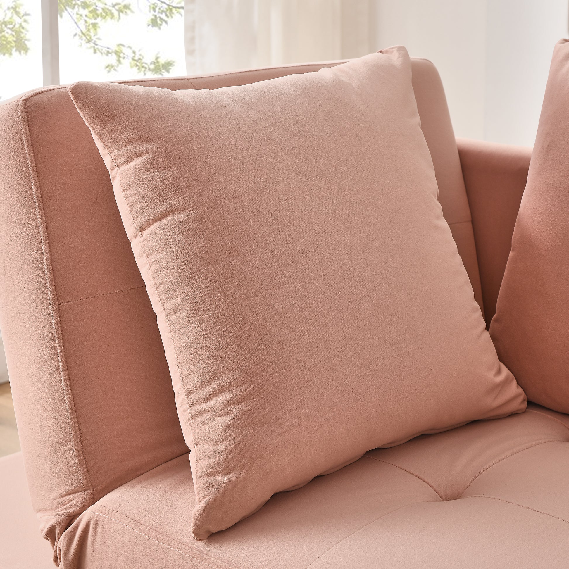 Soft pink velvet throw pillow on a matching tufted sofa for cozy living room decor