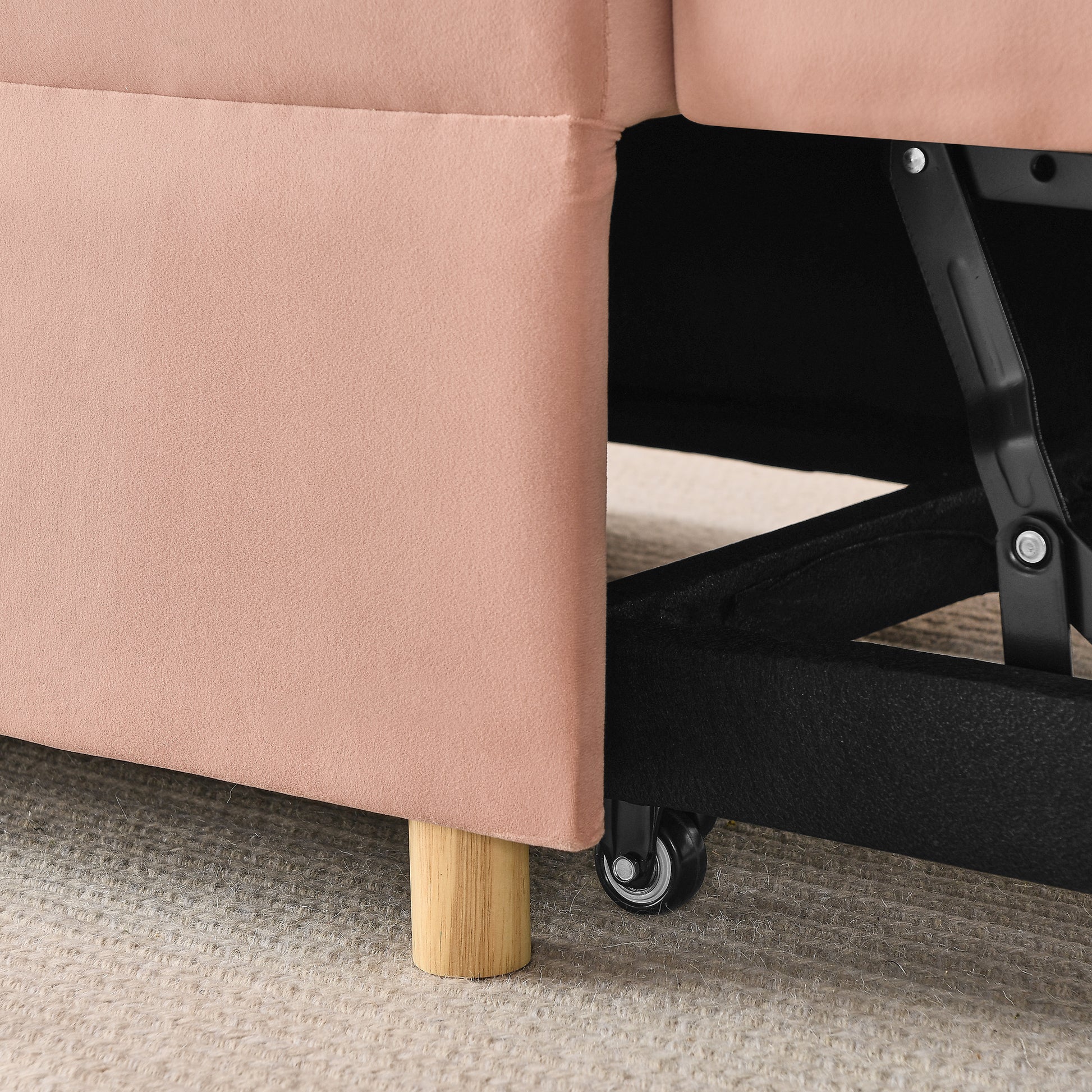Pink upholstered sofa base with wooden leg and black wheel detail
