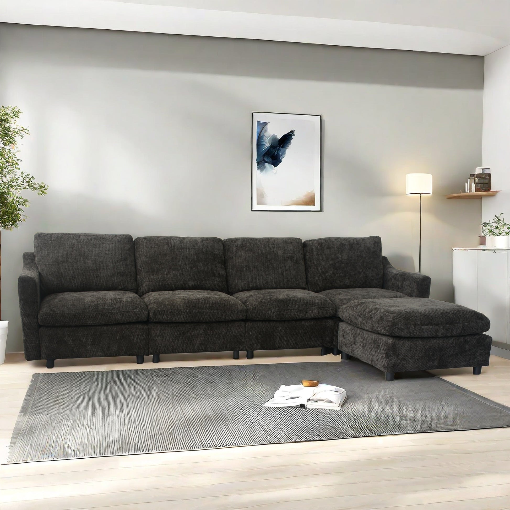 Dark charcoal fabric sectional sofa with chaise lounge on a grey rug