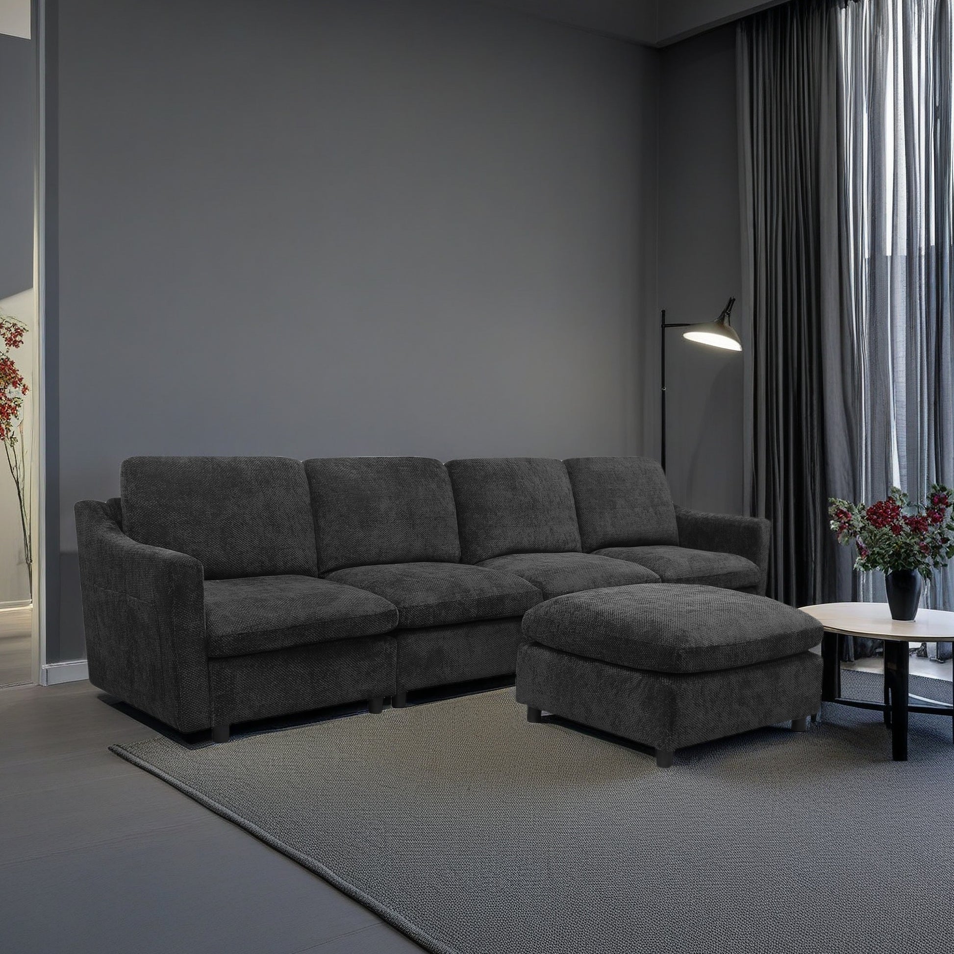 Deep charcoal modular sectional sofa with textured fabric upholstery featuring plush cushions and an ottoman