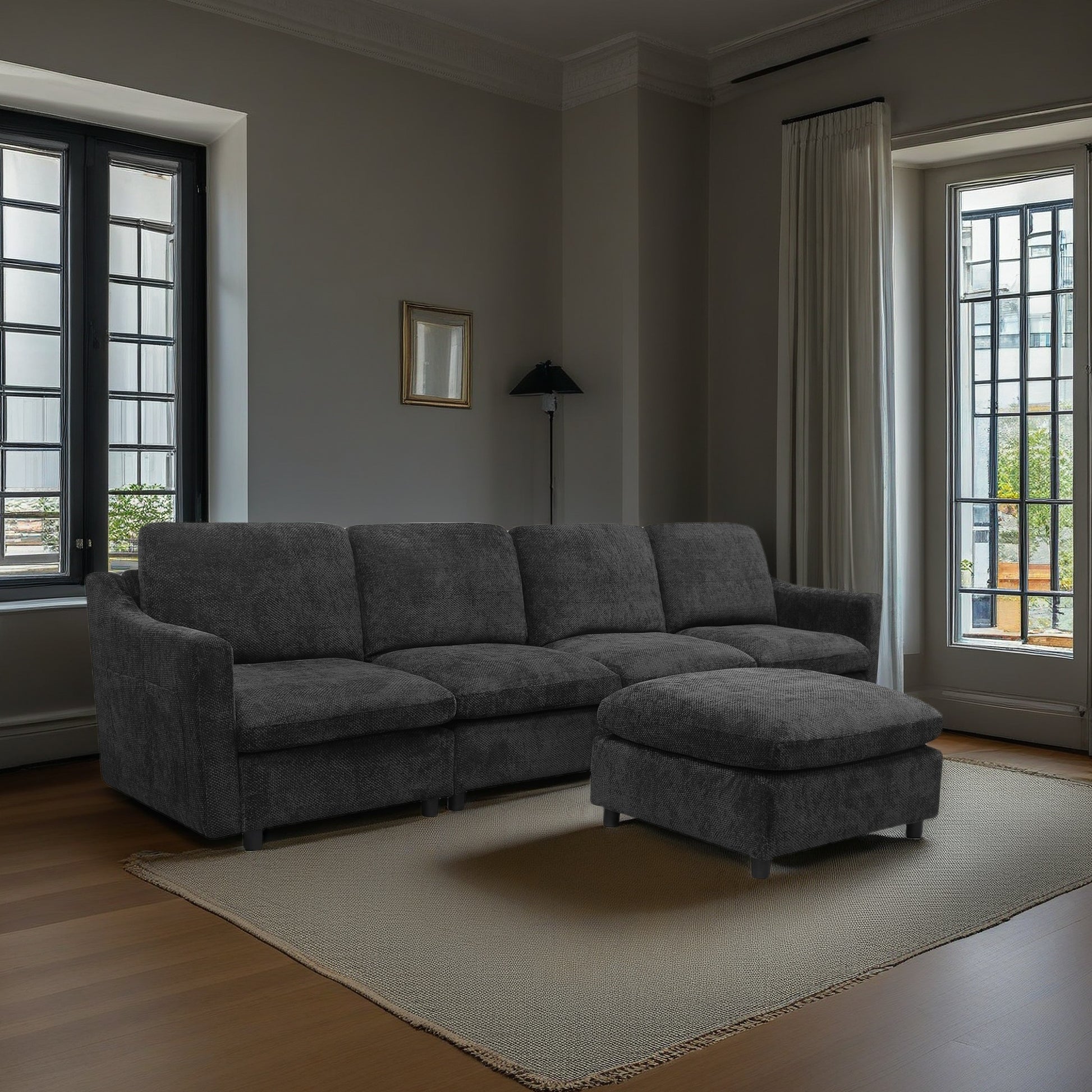 Dark charcoal fabric sectional sofa with matching ottoman in a living room setting