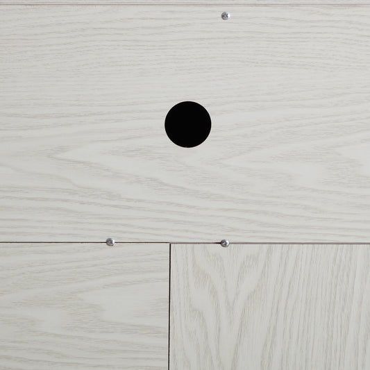 Closeup of light oak wood veneer panel with cable management hole