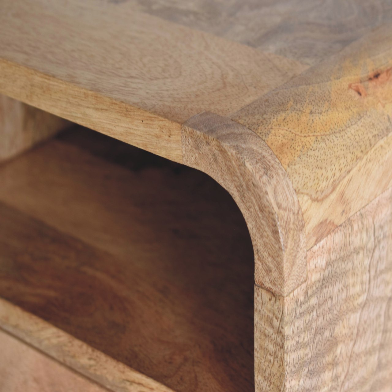 Closeup of light brown mango wood bedside table corner with smooth finish