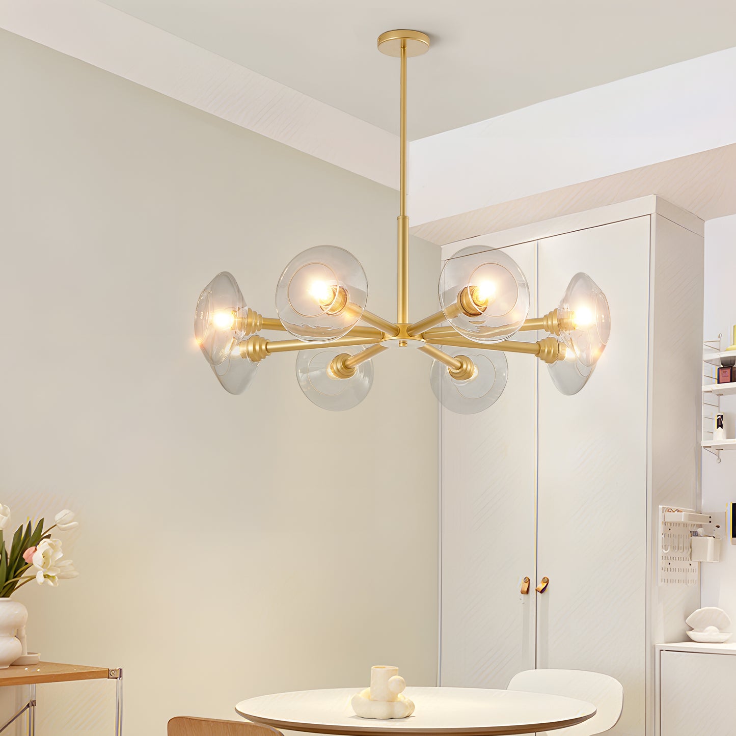 Modern brass chandelier with clear glass globe shades casting warm light