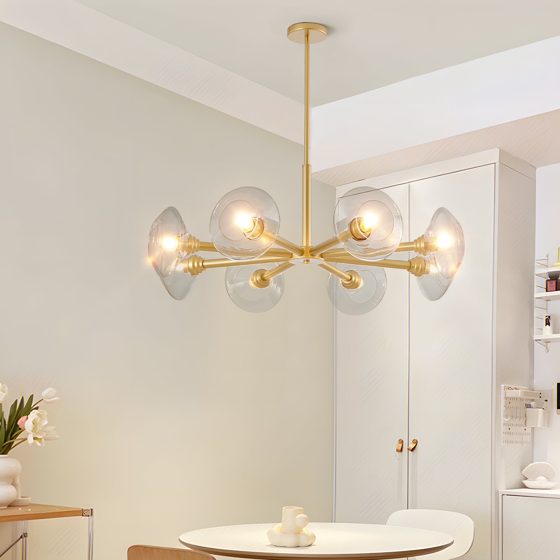 Modern brass chandelier with clear glass globe shades casting warm light