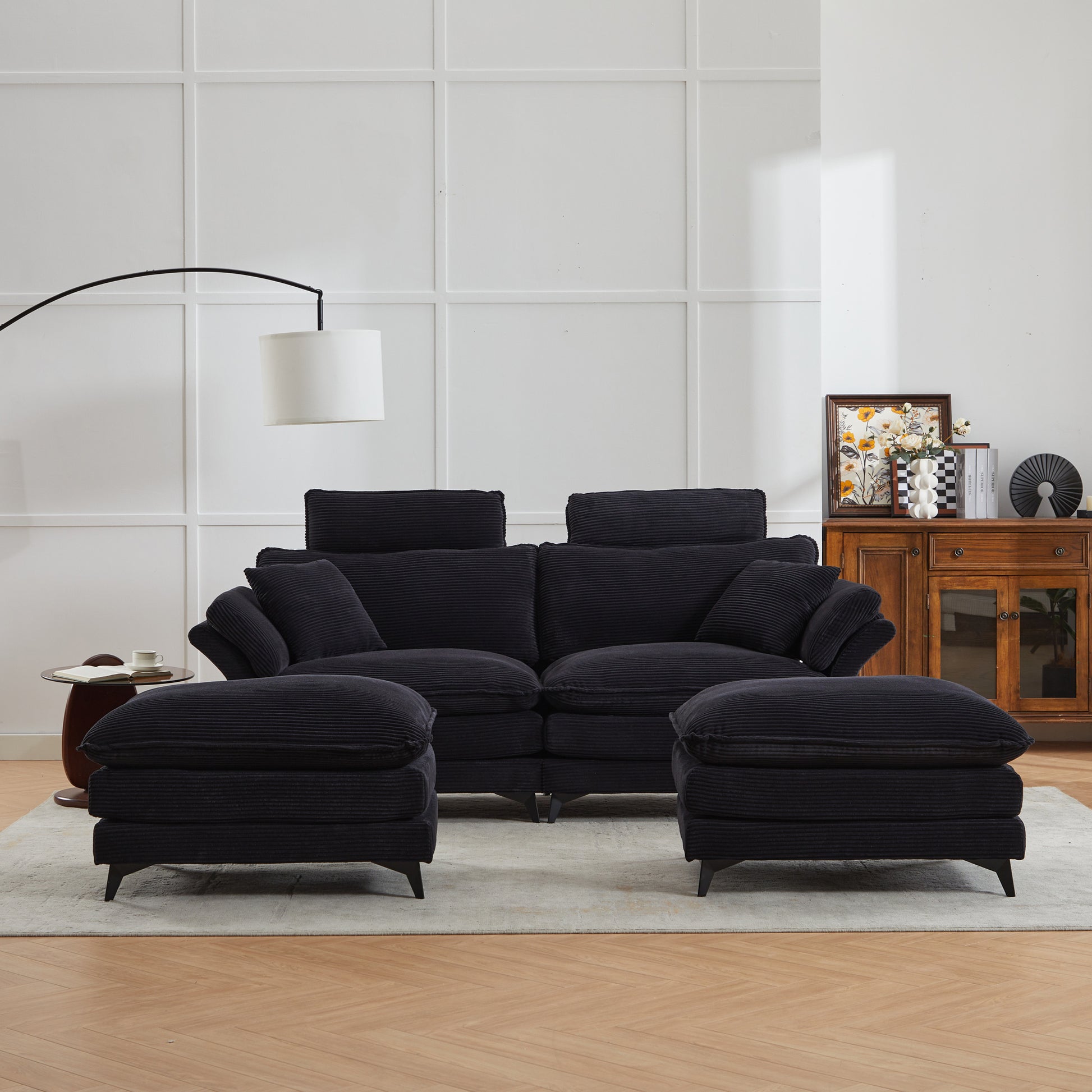 Plush black corduroy sectional sofa with deep seats and matching ottomans for a cozy living room setup