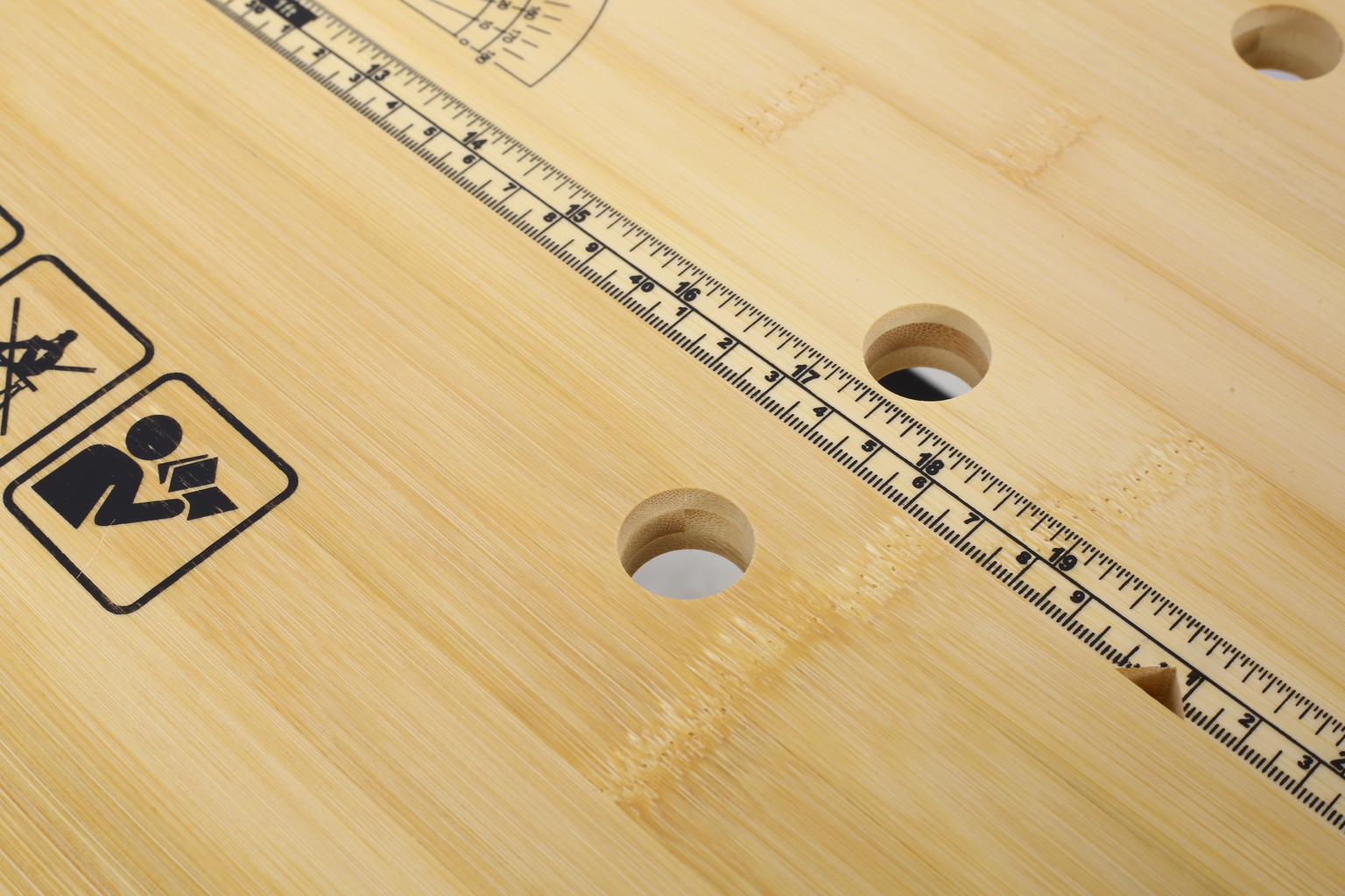 Closeup of natural bamboo workbench with integrated ruler markings and circular holes