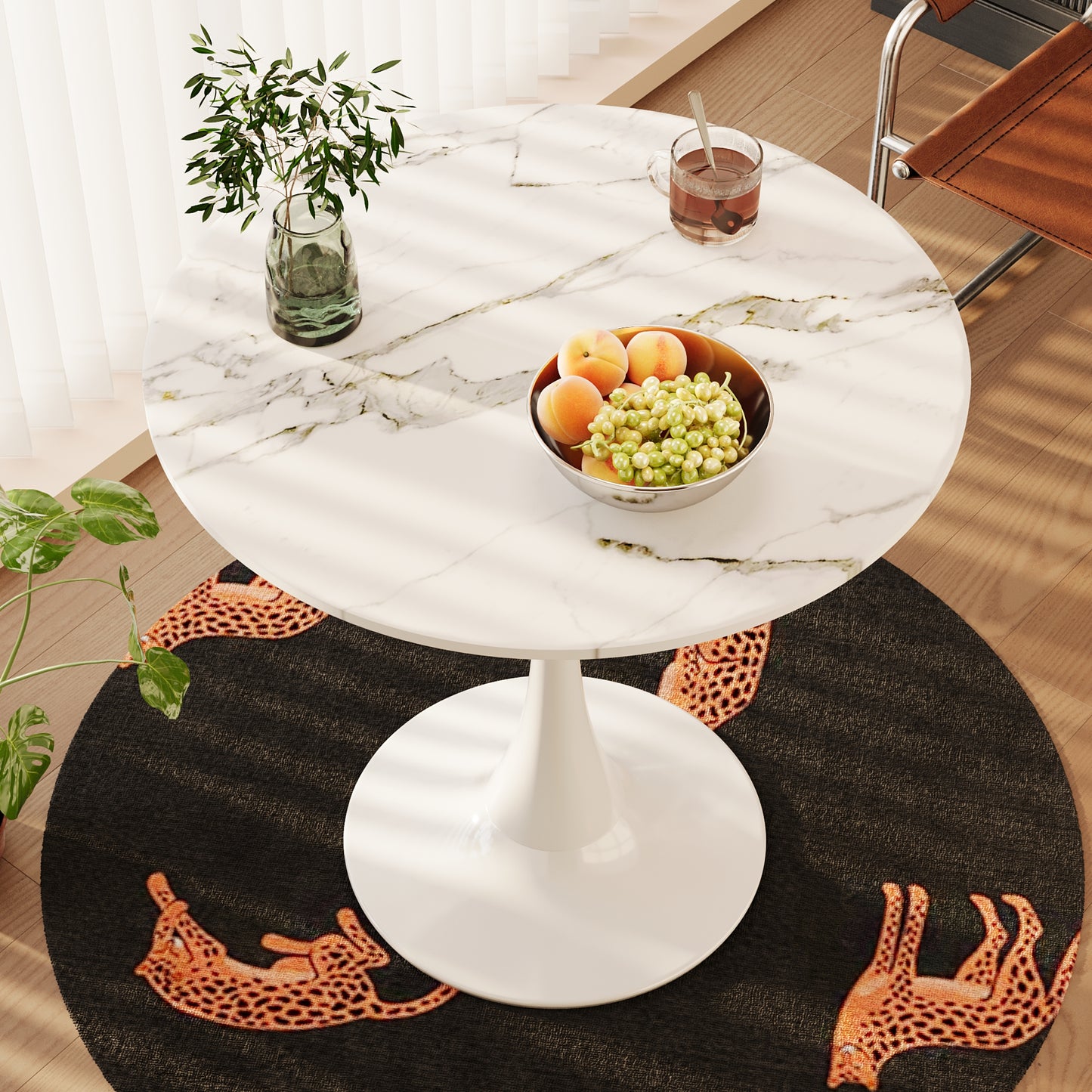 Modern white marble tulip table with a glass of tea and fruit bowl