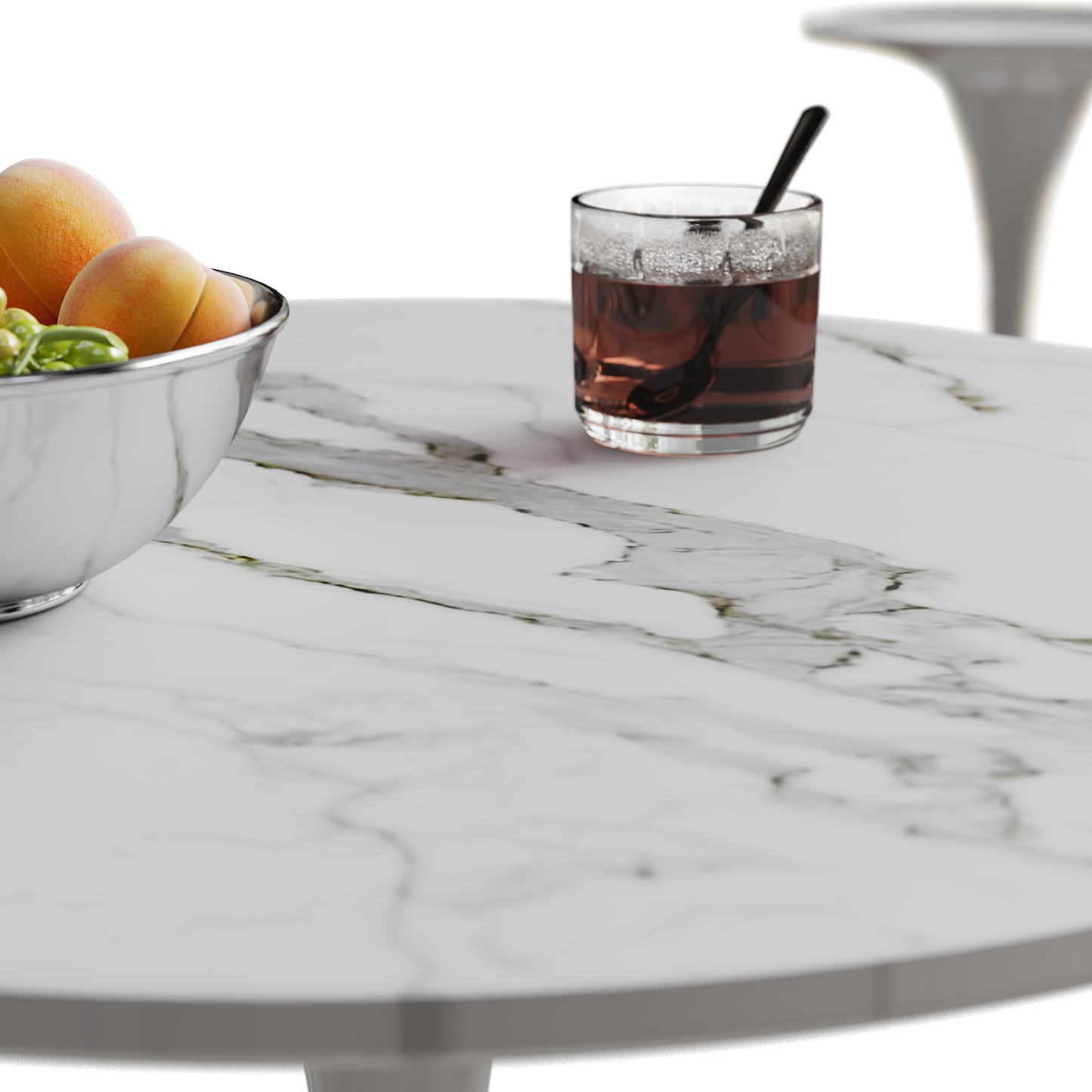Silver serving bowl filled with ripe peaches and green grapes on a marble table