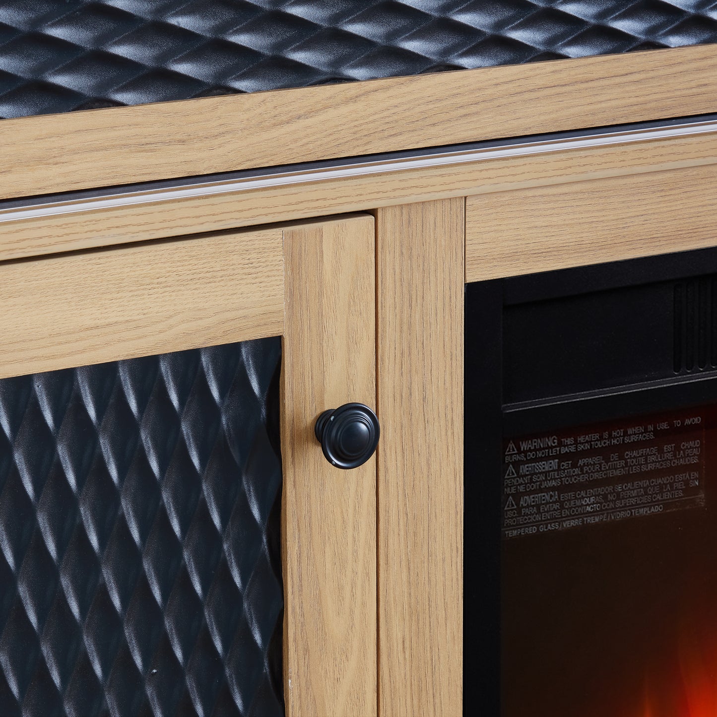 Oak wood cabinet with black diamondpatterned panel and black knob part of an electric fireplace
