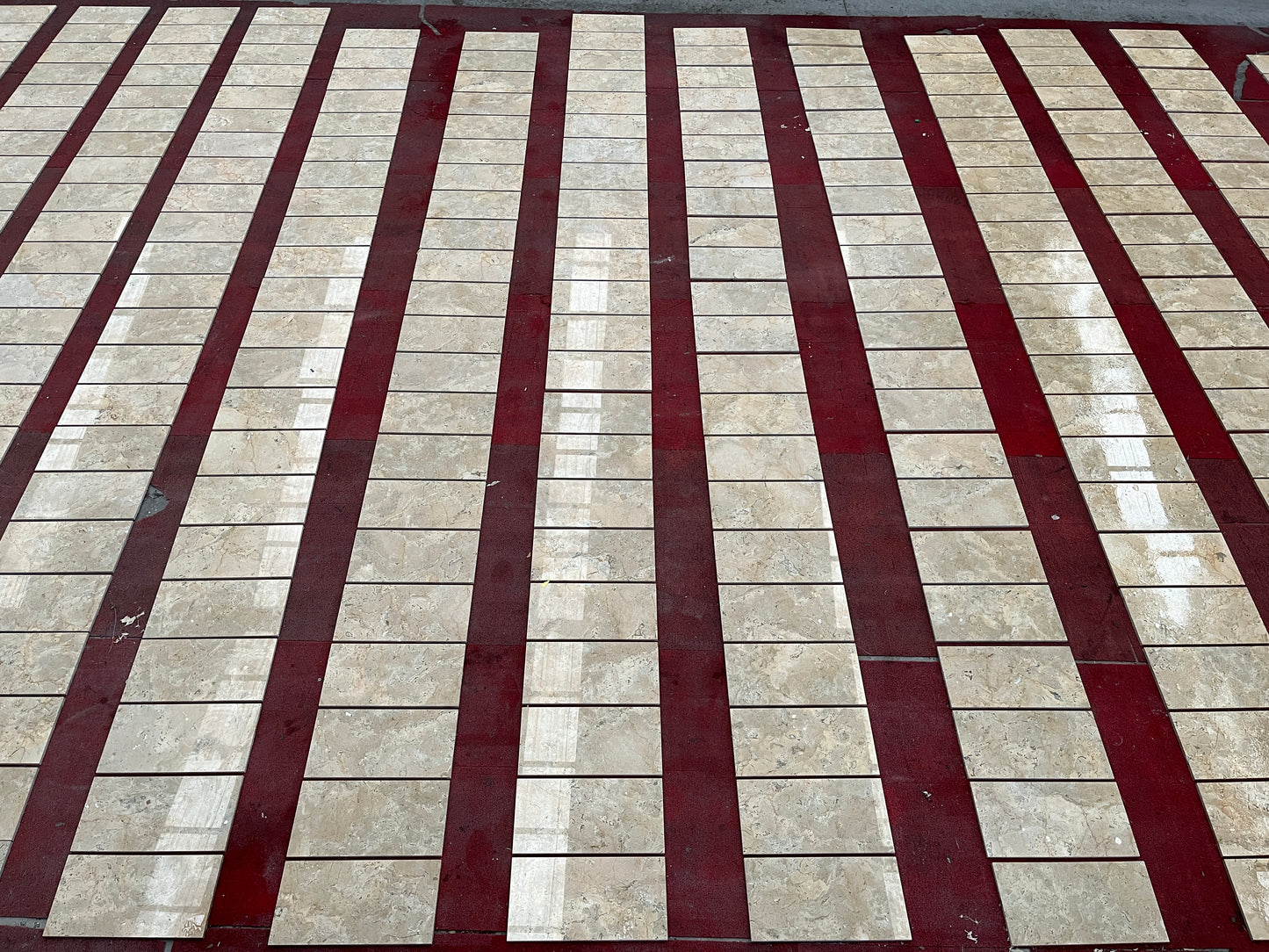 Beige marble subway tiles with red grout for a striking floor or wall design