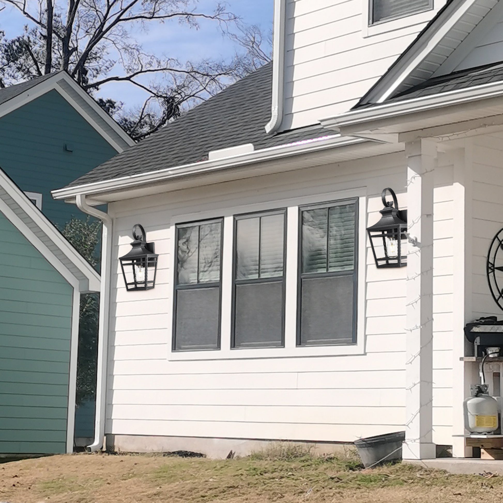 Classic black outdoor lantern with clear glass panes mounted on white siding