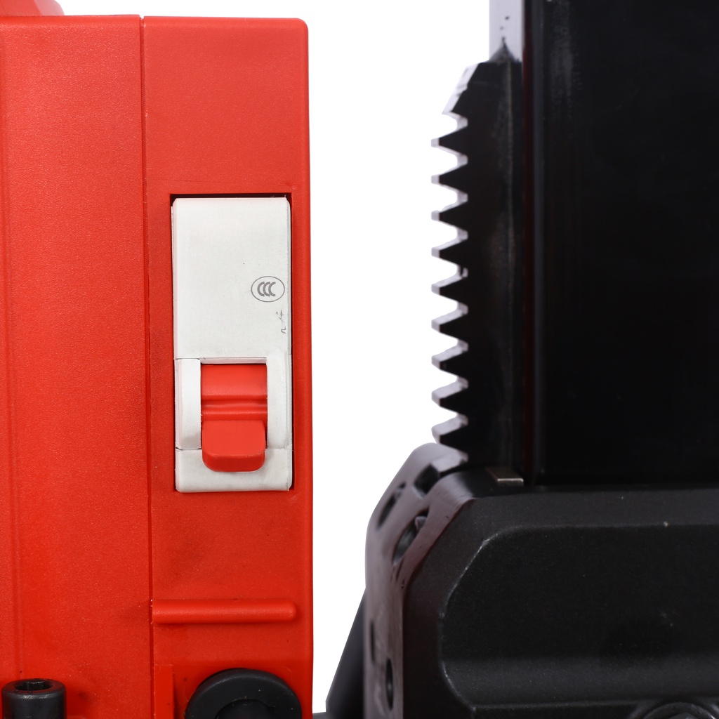 Red industrial drill with a prominent red switch and black serrated gear mechanism