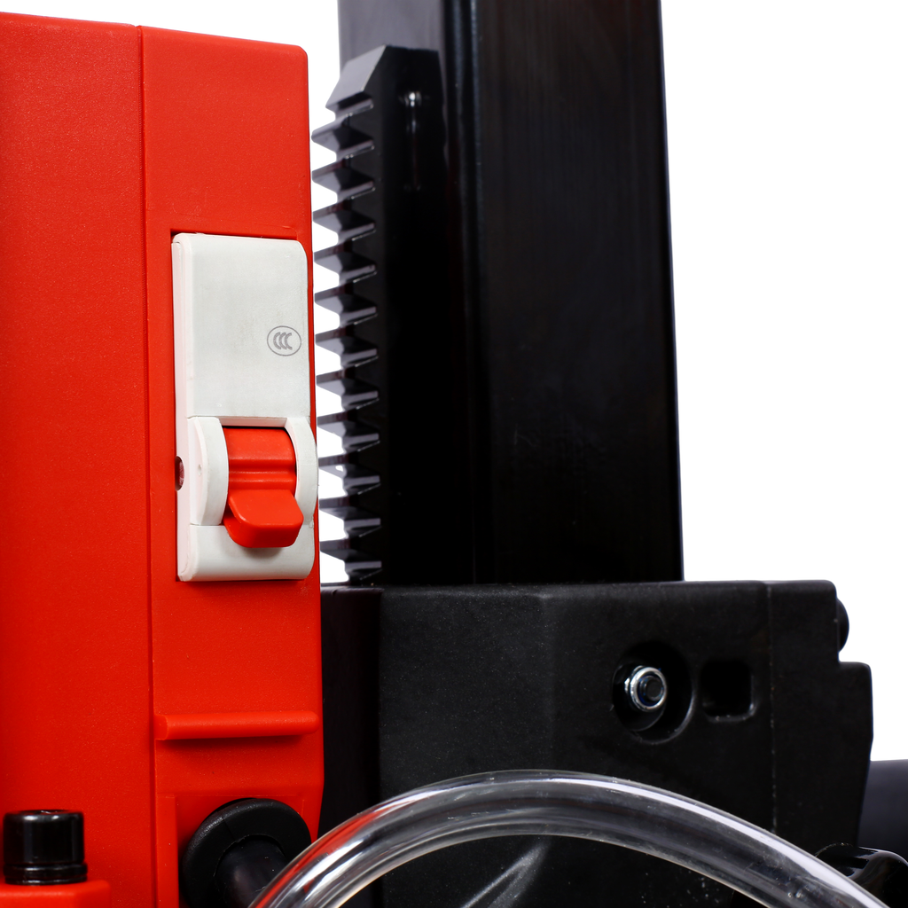 Red and black industrial drill press with prominent red toggle switch