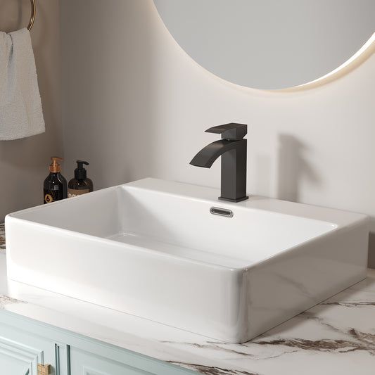 Modern matte black waterfall bathroom faucet on a white rectangular sink