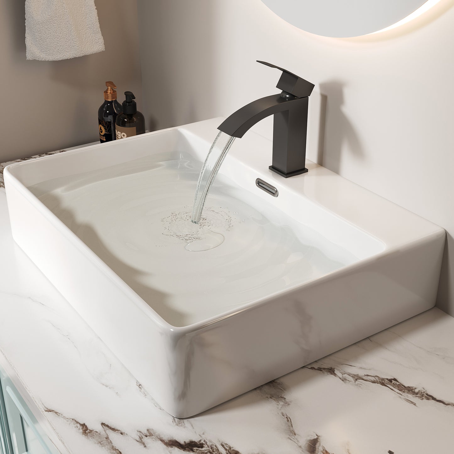 Sleek matte black waterfall faucet cascading into a white ceramic vessel sink with marble countertop